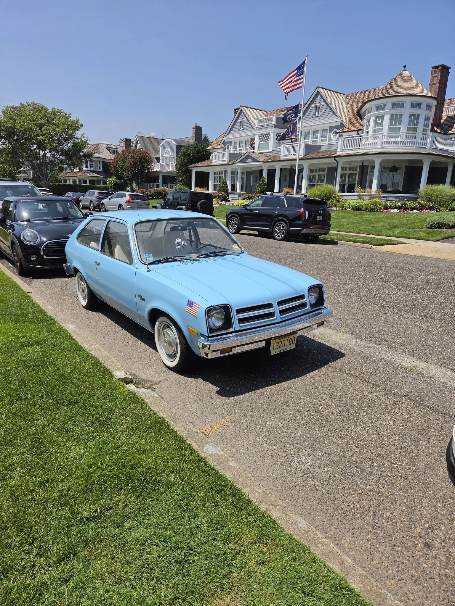 Powder-blue vintage Chevy Chevette parked in front of a large shore-style home in Monmouth County