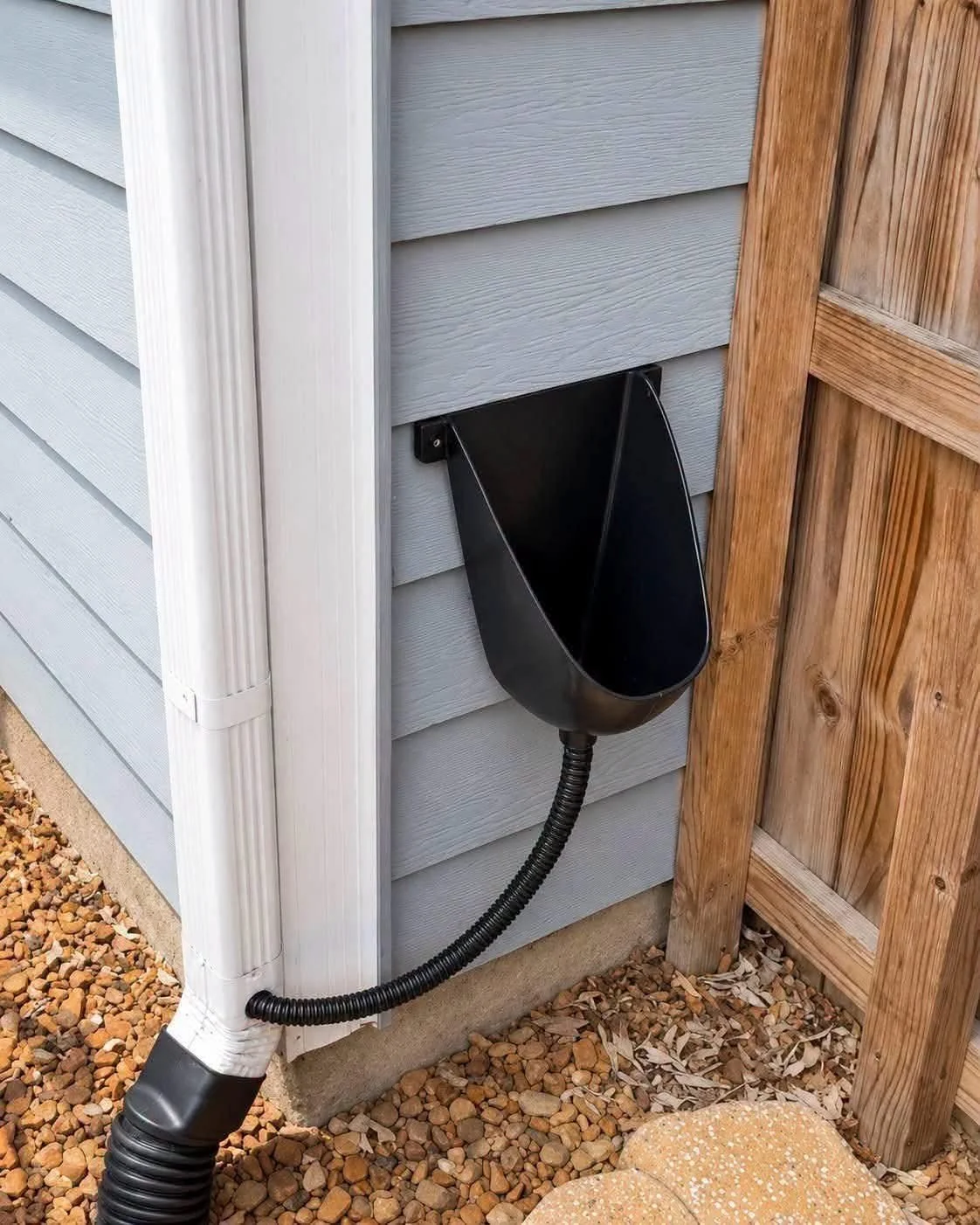Outdoor wall-mounted urinal plumbed into a gutter downspout