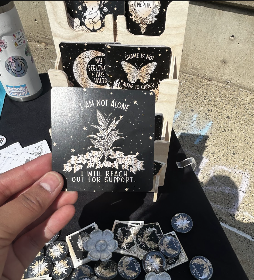 Table with affirmation cards/stickers and someone holding up one of the affirmation cards