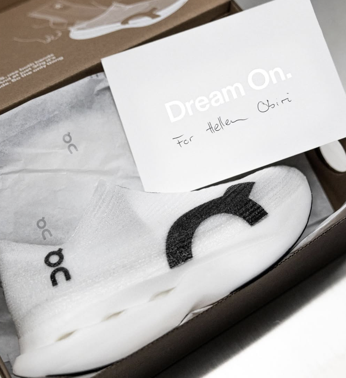 Close up of an On's Zone Dreamers shoe in a box with a note reading 'Dream On. For Hellen Obiri'