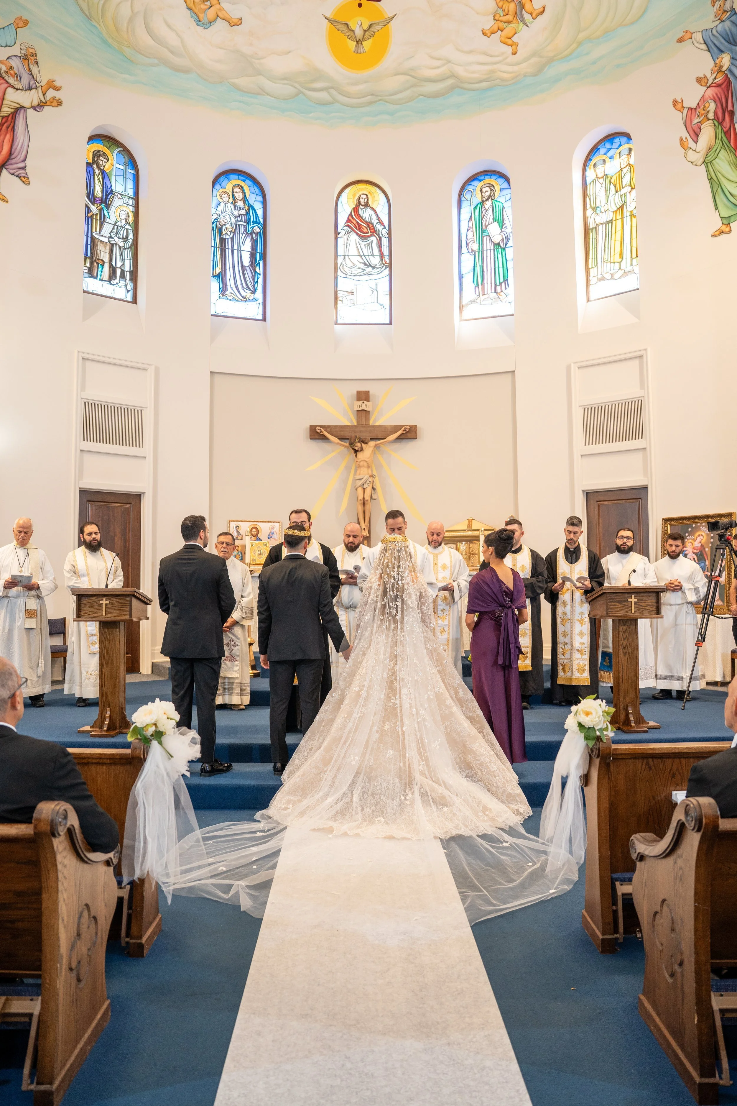Wedding ceremony at the altar of a church with painted ceilings and stained glass windows