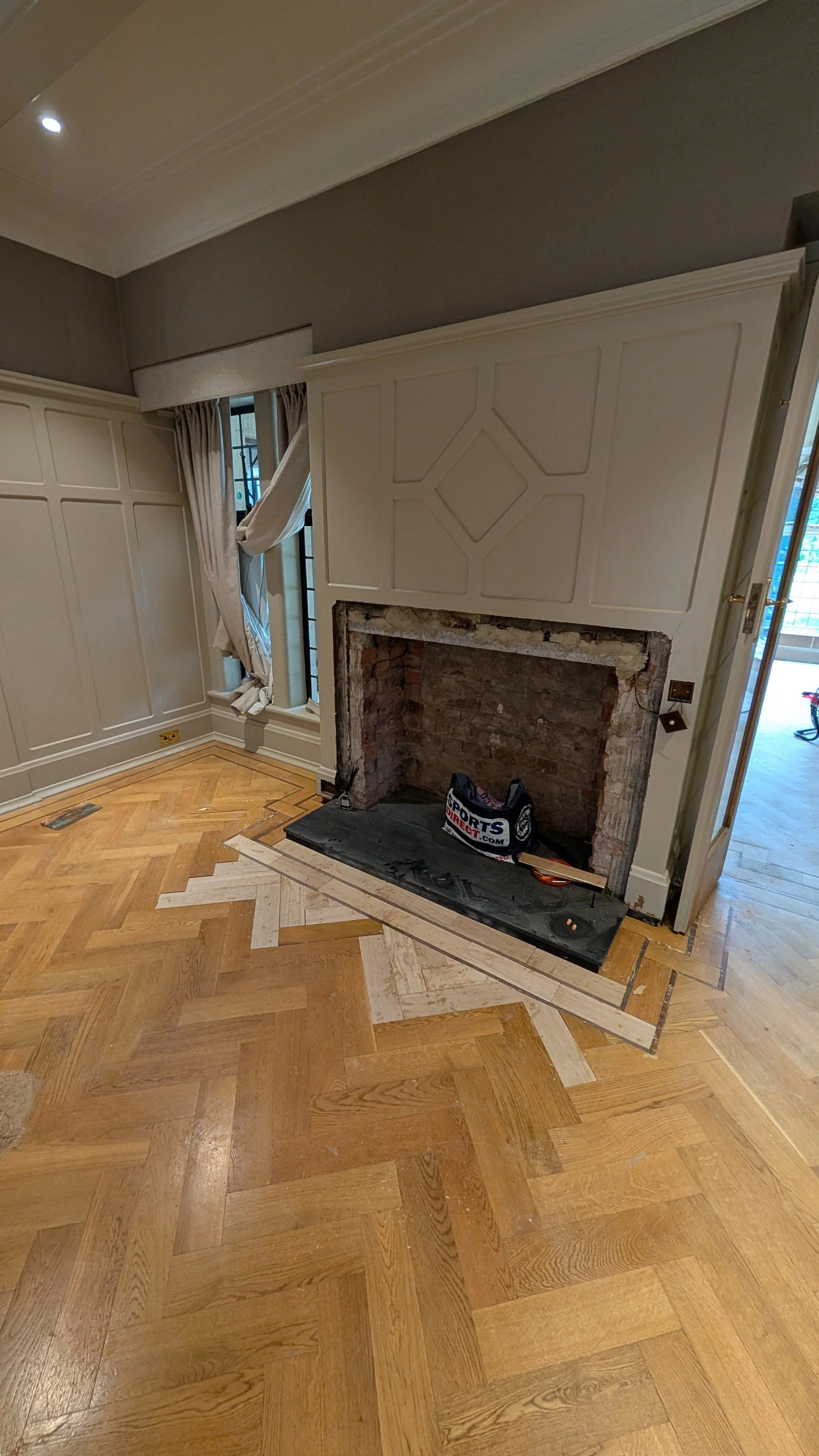 Parquet being patch repaired around a fire surround
