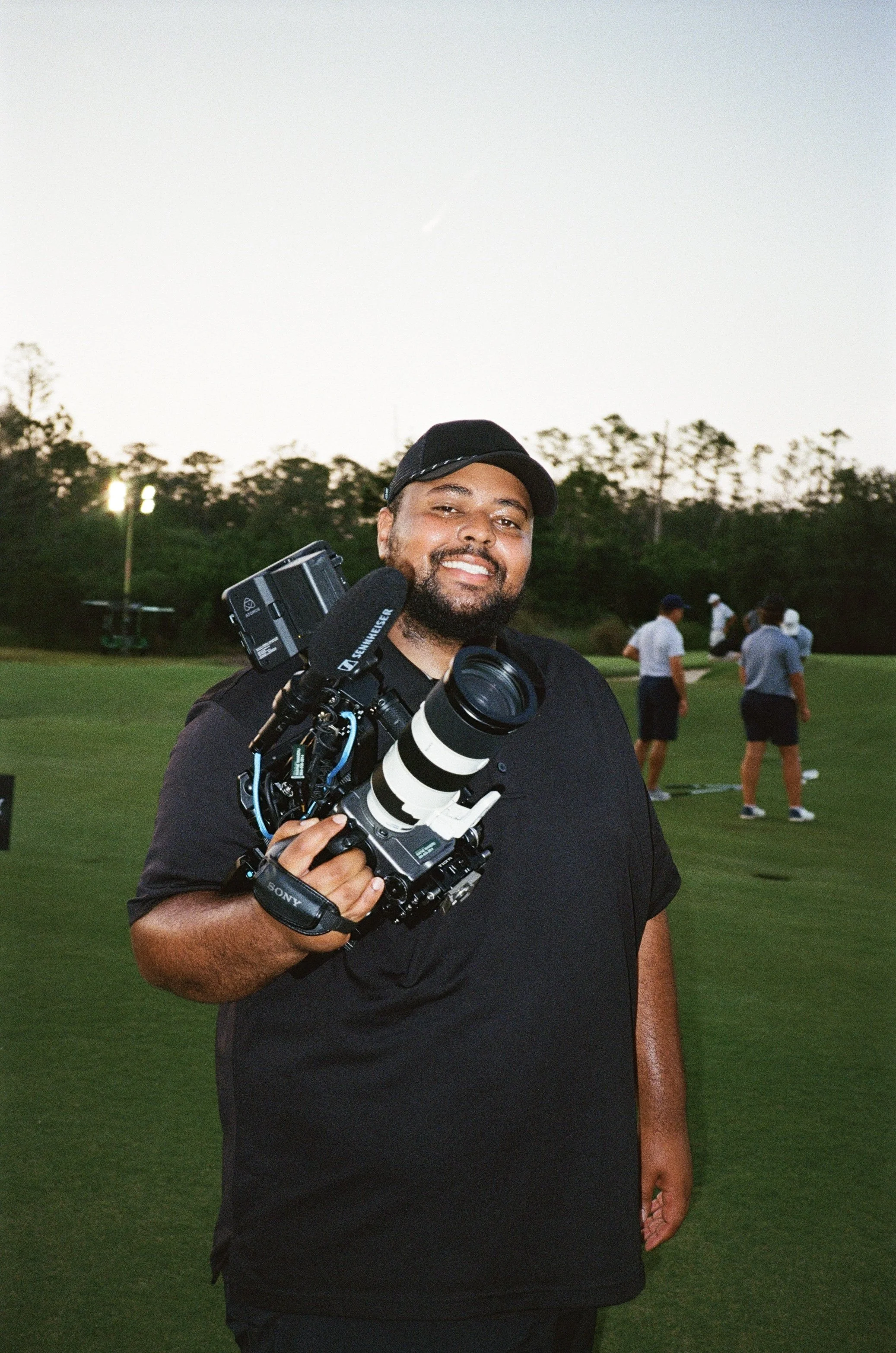 Professional videographer holding a Sony cinema camera while filming a golf event in Spartanburg, South Carolina.