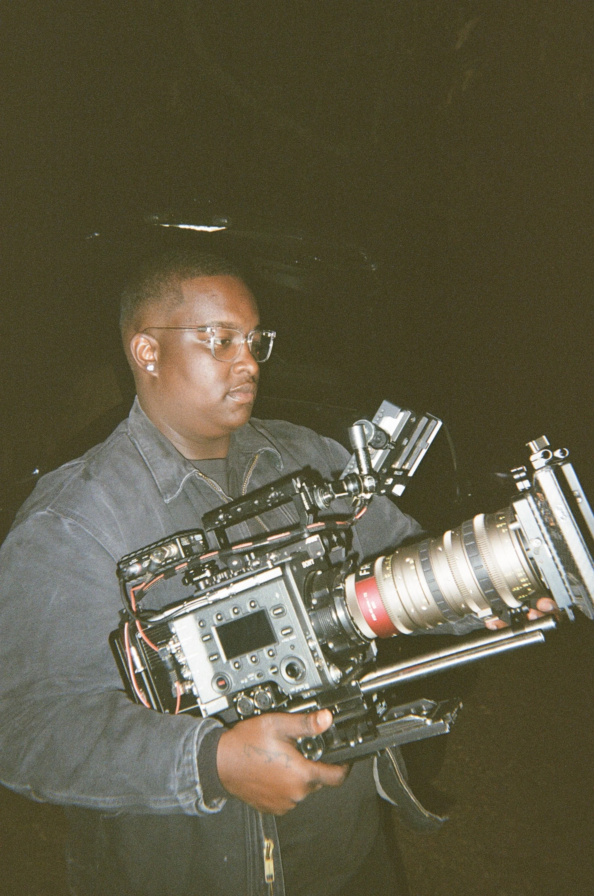 Professional cinematographer operating a fully rigged cinema camera during a commercial video production.