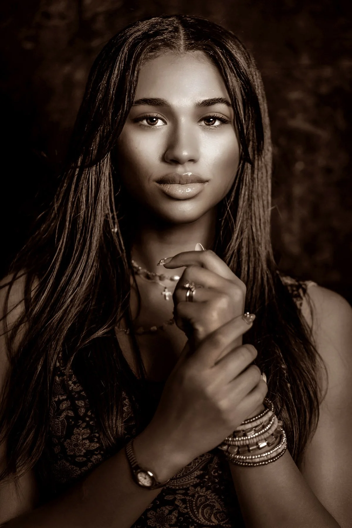 glam portrait of beautiful woman with dark skin and long hair and bracelets. 