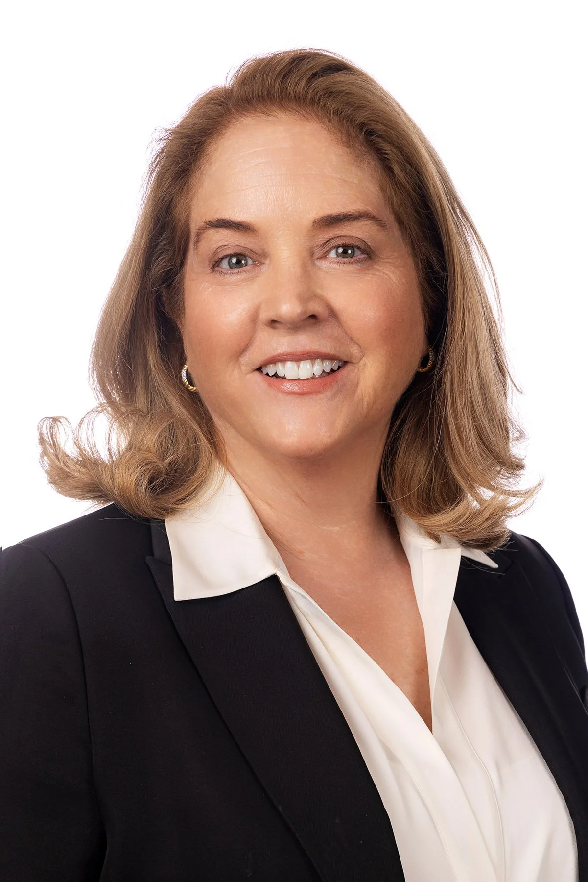 Professional woman with shoulder-length brown hair, smiling, wearing a black blazer and white blouse, against a plain white background. Salt Lake City Portrait & Headshot Photographer - Nick Sokoloff - Utah