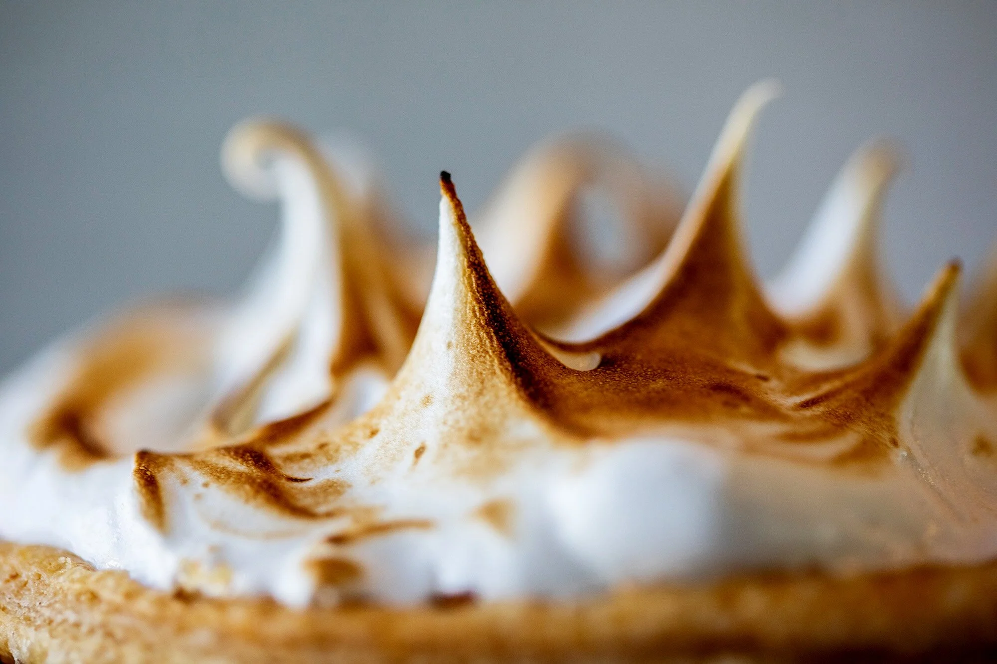 Close-up of toasted meringue with peaks on a dessert.