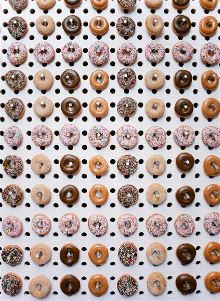  Peg board filled with an array of donuts 