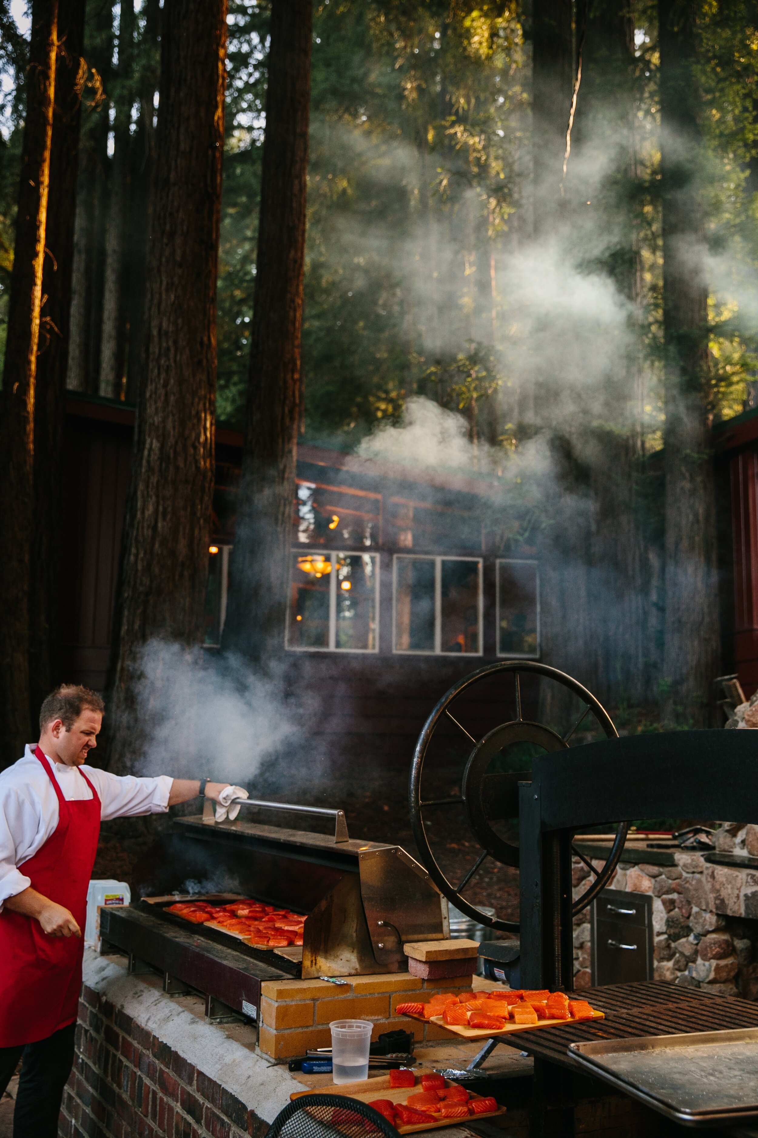  Chef cooking grilled cedar plank salmon in a forrest 