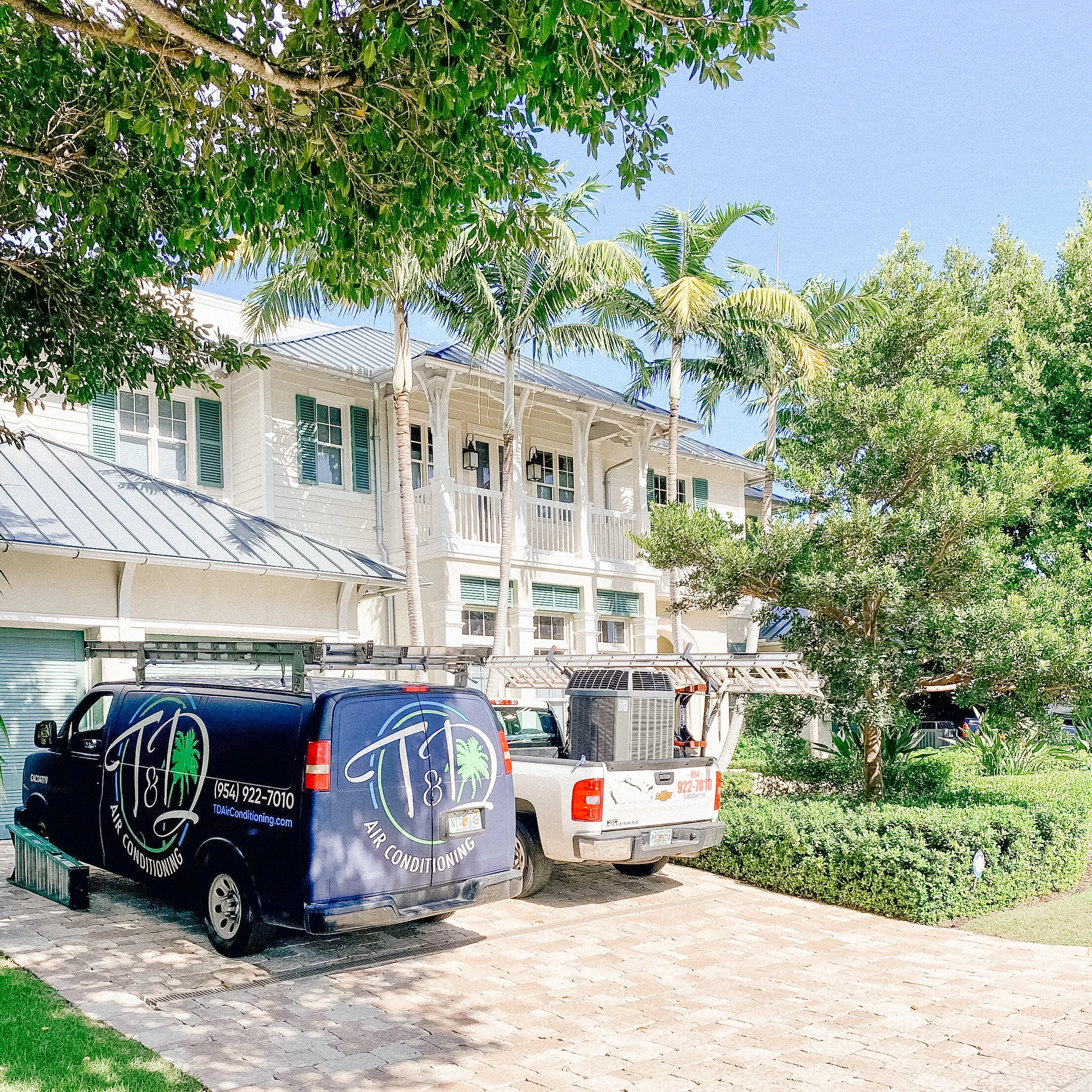 T & D Air Conditioning service vehicles at a residential property providing HVAC repair and maintenance services