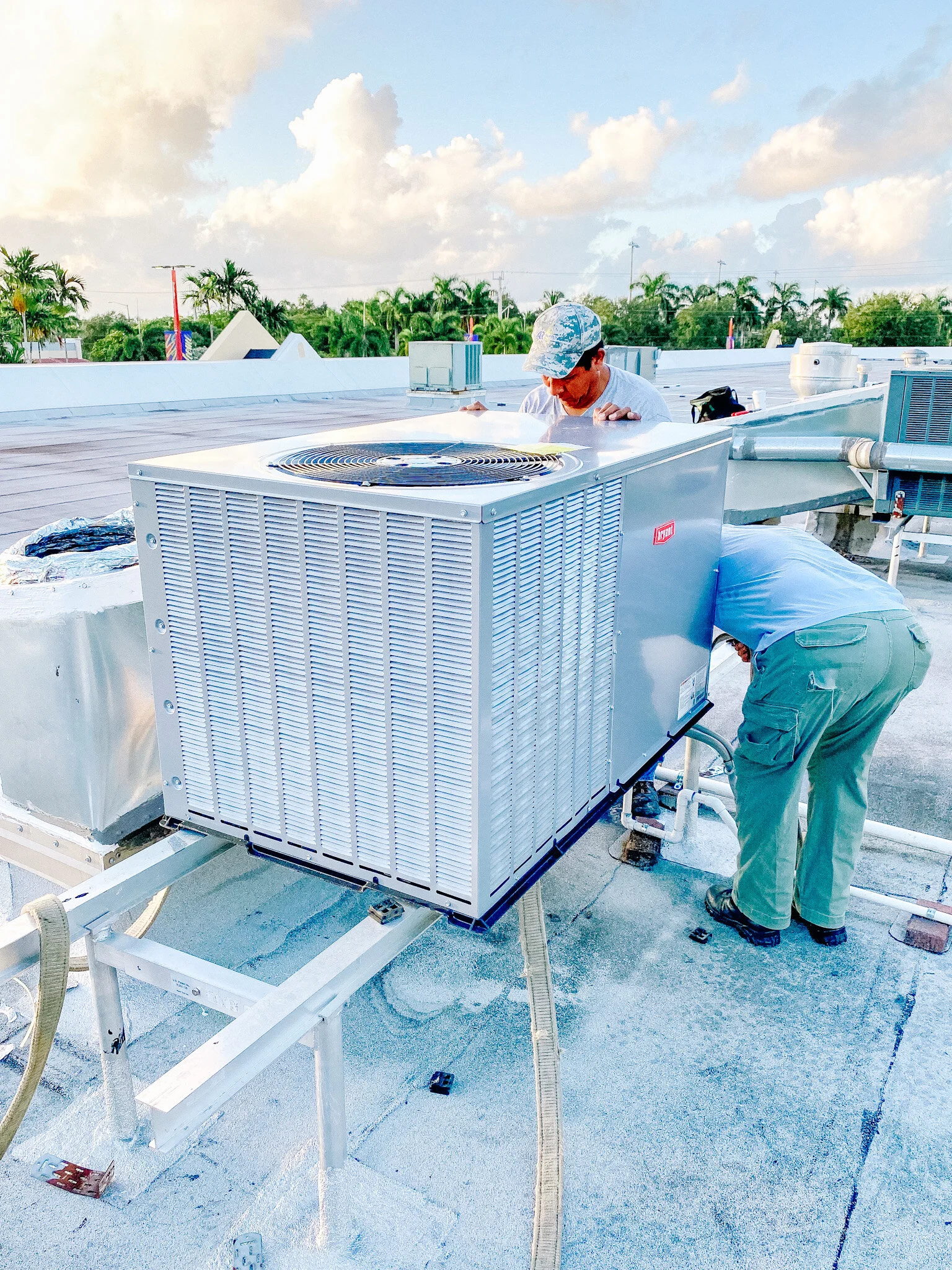 Technician performing rooftop HVAC maintenance on a commercial air conditioning unit in South Florida