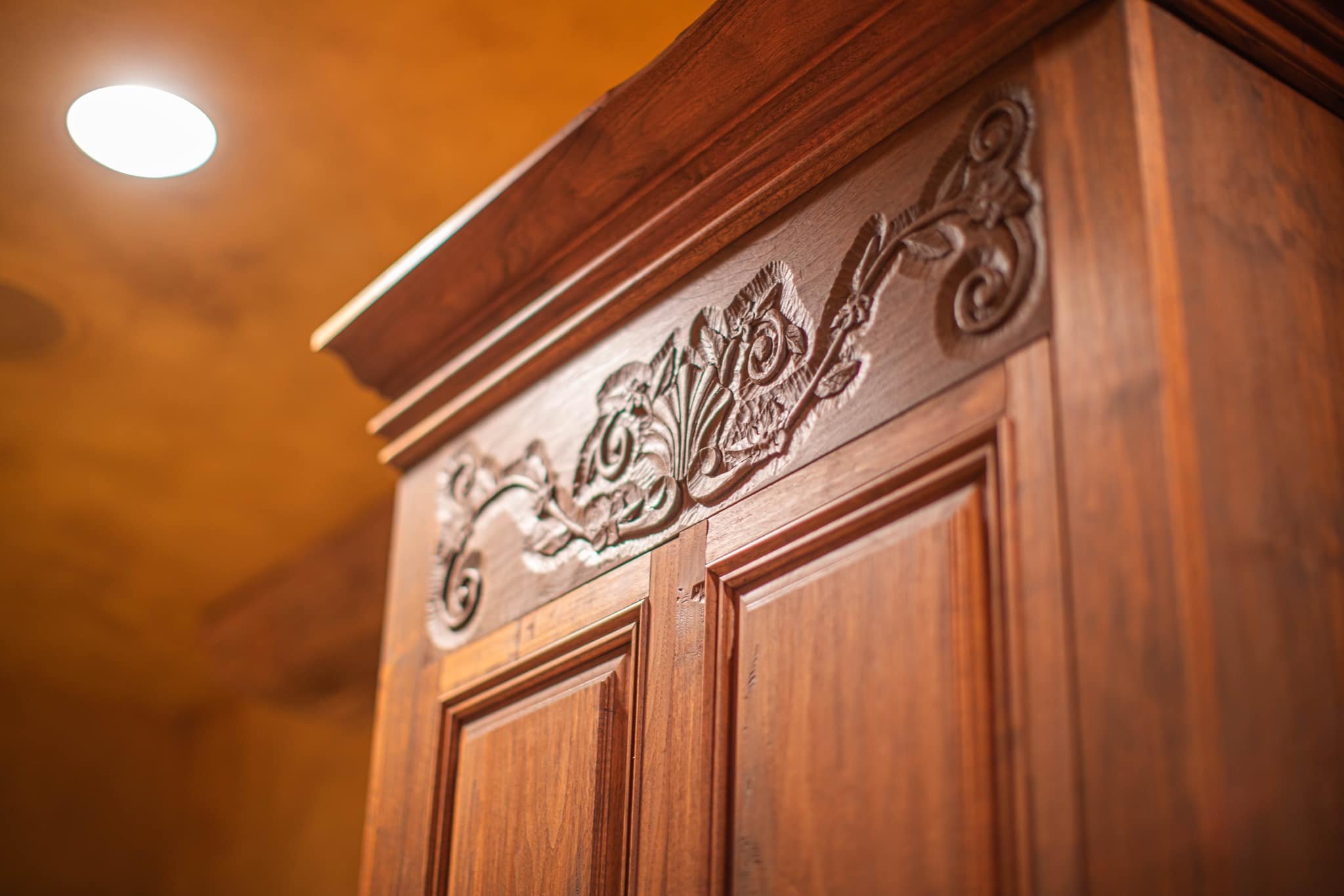Close-up of a wooden furniture piece with intricate carved floral design.