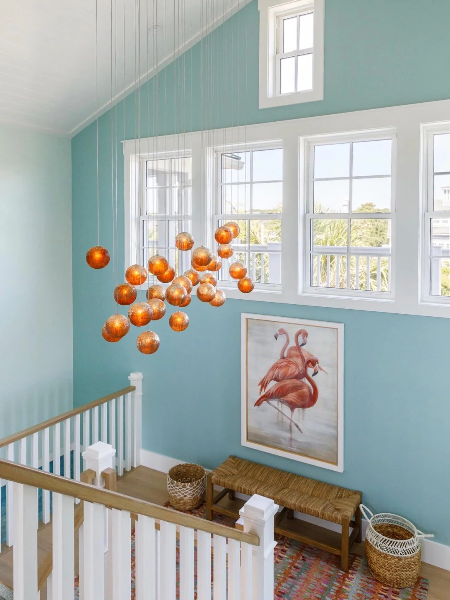A staircase moment that stops you in your tracks ✨ From the soft coastal hues to the statement chandelier glowing like suspended sunset, every detail was designed to turn a pass-through into a showpiece. Proof that even the in-between spaces deserve 
