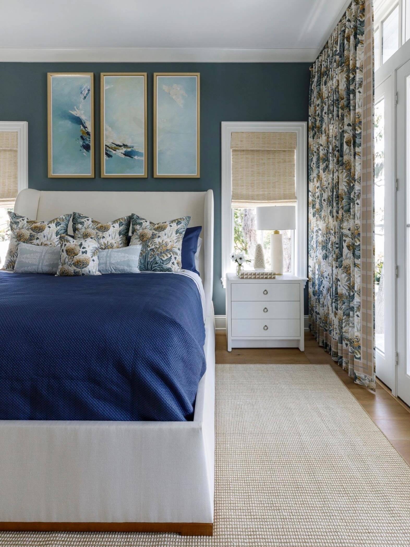 Layered patterns, rich textures, and a moody coastal palette that makes this bedroom feel like a true retreat. From the tailored drapery to the deep navy bedding, every detail was designed to bring warmth, depth, and effortless elegance into the spac
