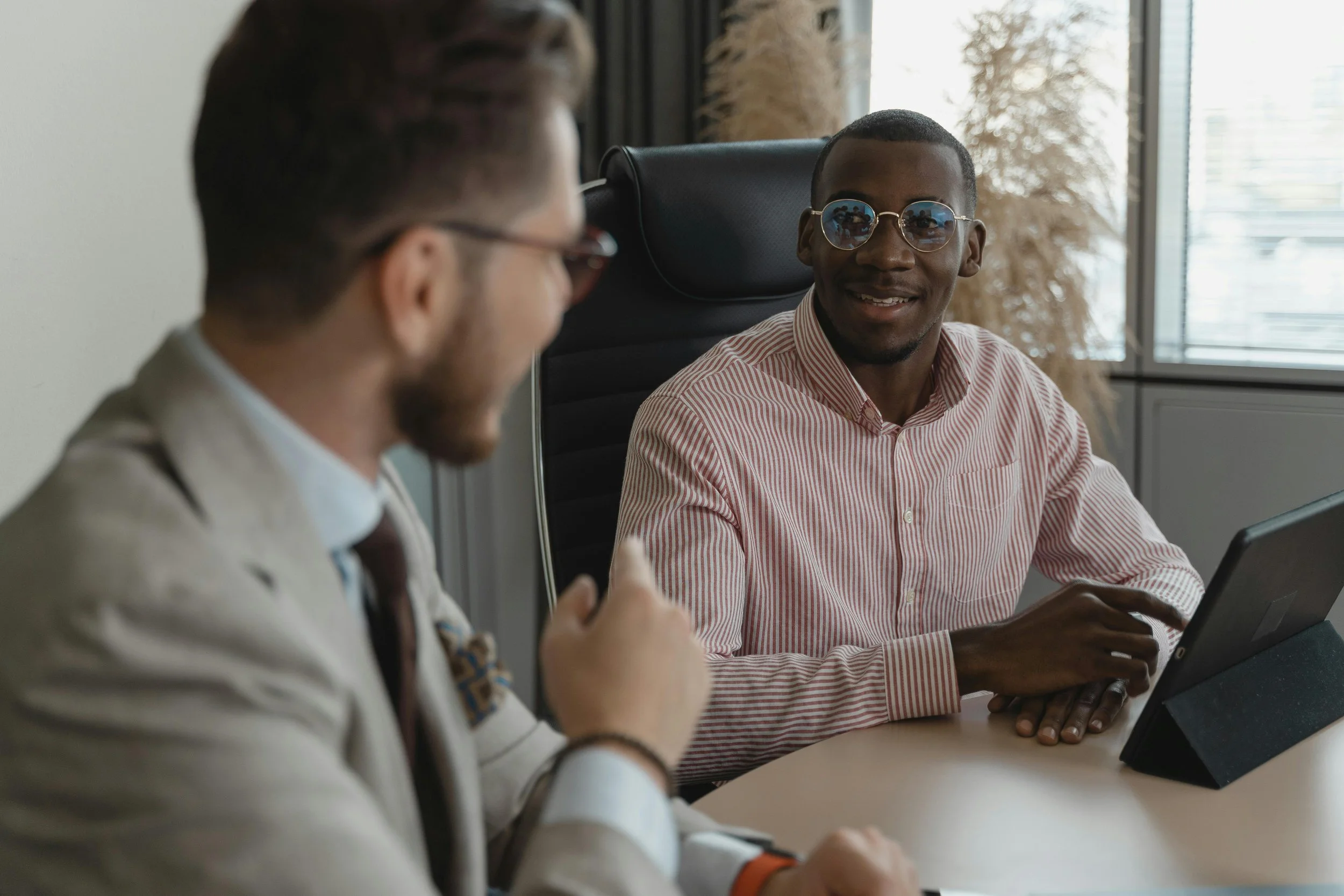 Two professionals having a respectful conversation in an office setting.