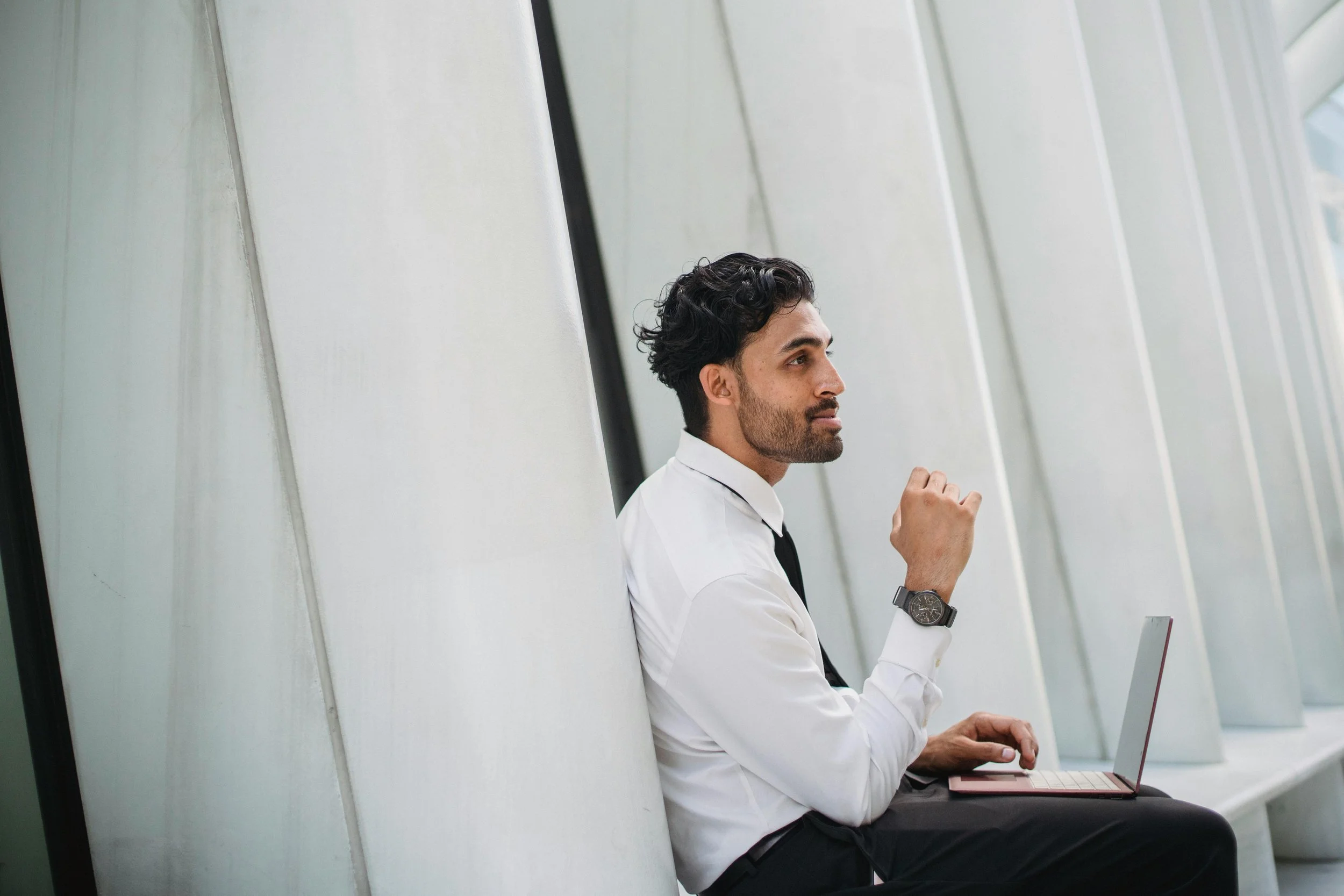 Business professional sitting quietly and reflecting with a focused expression.