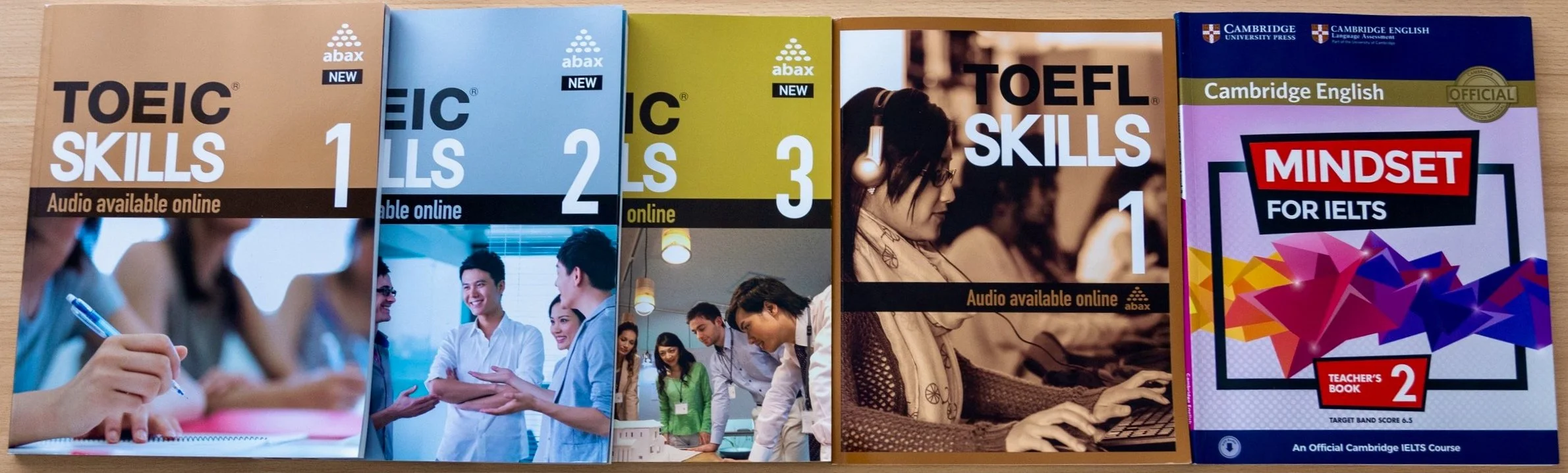 TOEICとTOEFLの学習書籍が3冊とIELTSの教師用ガイドブックが1冊並んでいます。