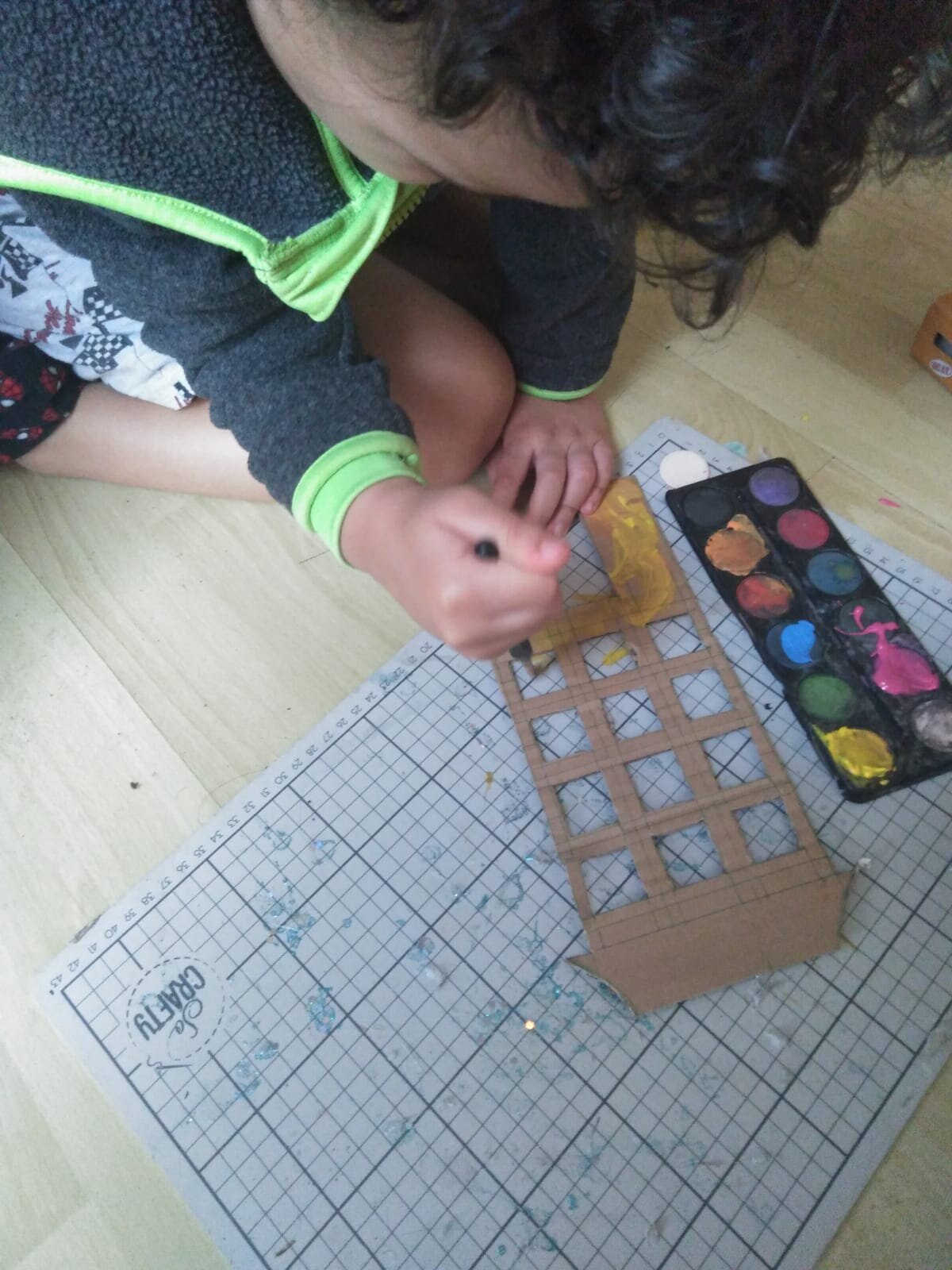 Boy painting cut out cardboard houses
