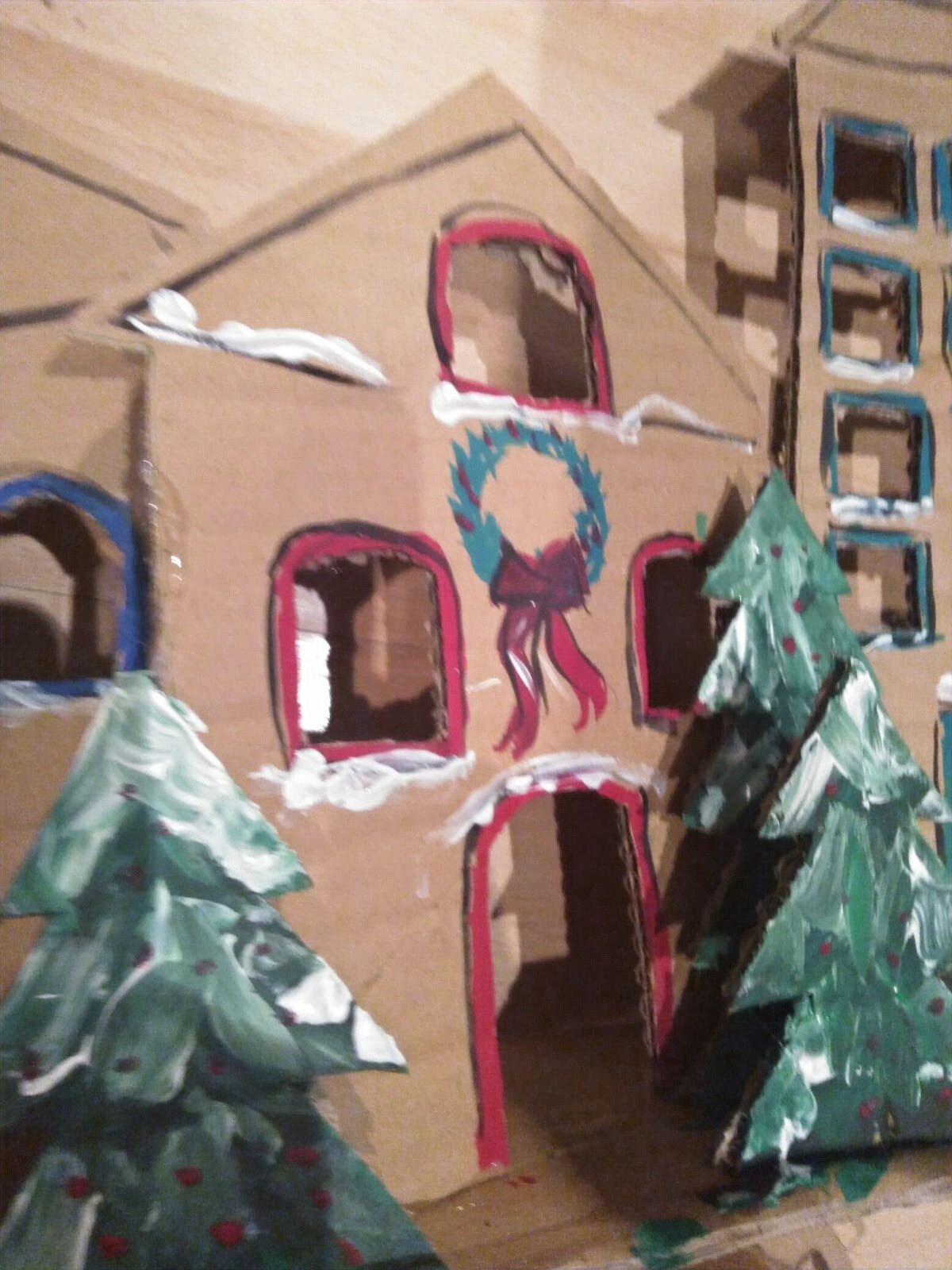 Cut out cardboard houses painted in a Christmas style