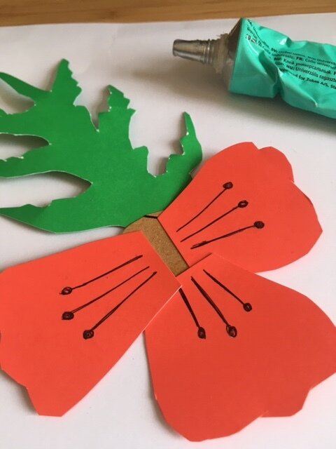 Gluing petals and leaves onto a paper poppy