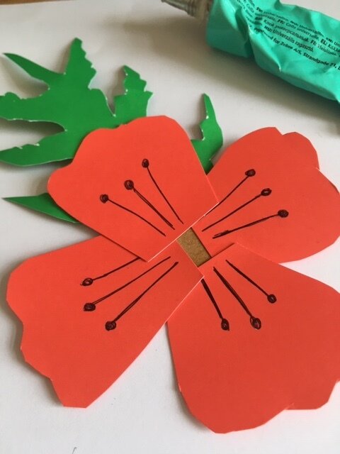 Gluing petals and leaves onto a paper poppy