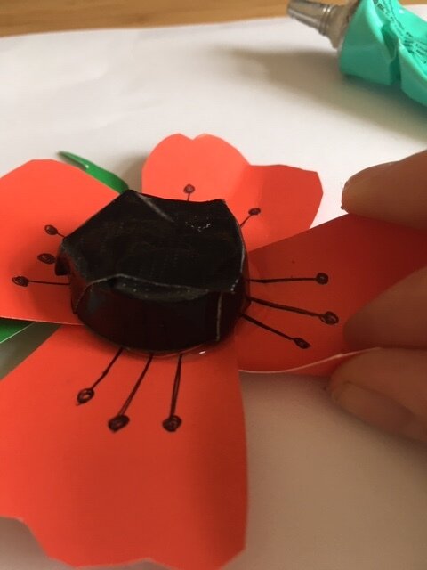 Pinching petals on a paper poppy to a little to give them some shape
