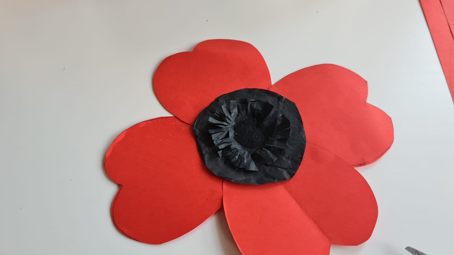 A finished paper poppy with black tissue centre