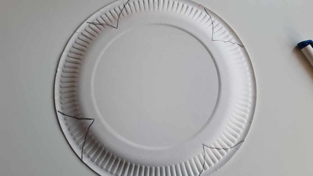 A poppy shape drawn on the back of a white paper plate