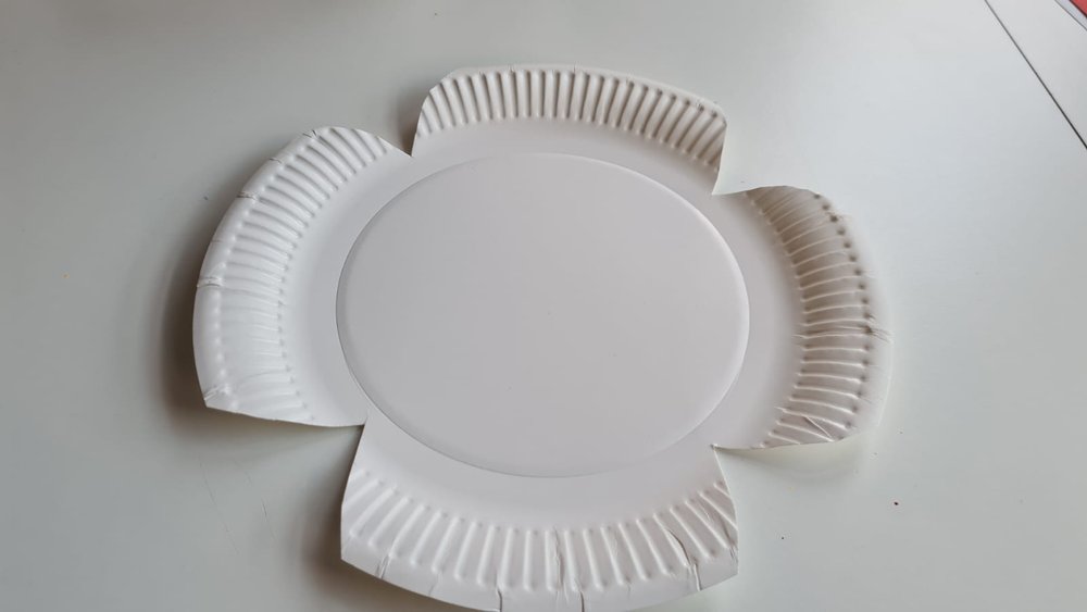 A white paper plate cut into a poppy shape