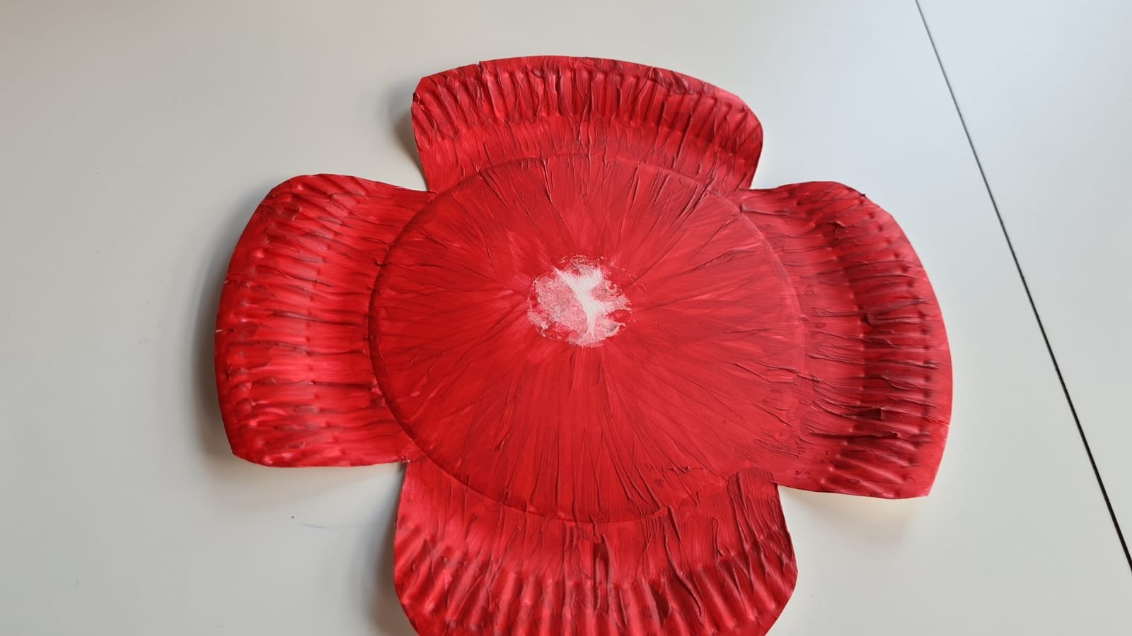 Paper plate cut into poppy shape and painted red