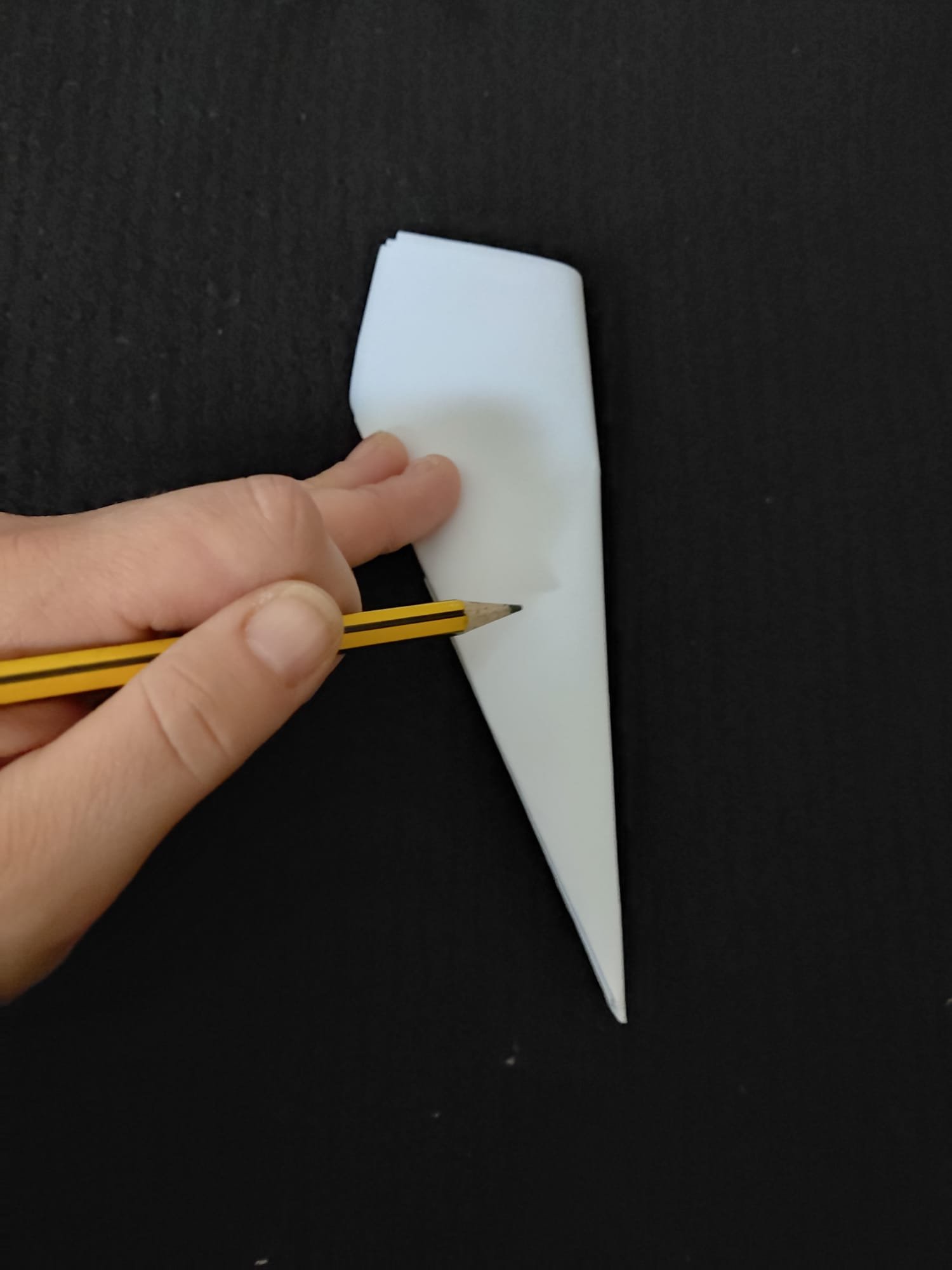 Drawing a snowflake design on a folded triangle piece of paper