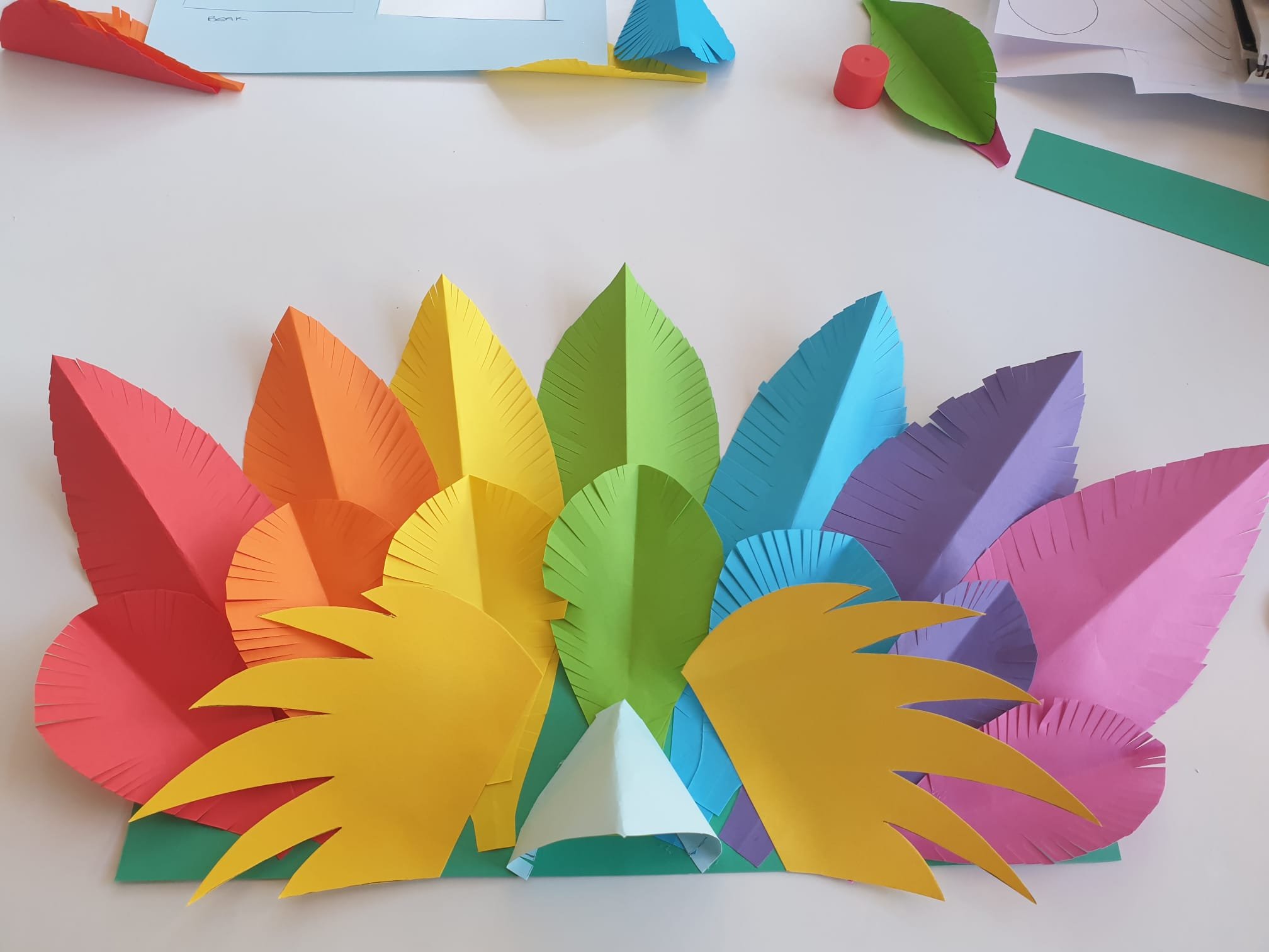Feathers stuck to the side of the beak on the rainbow bird carnival headdress