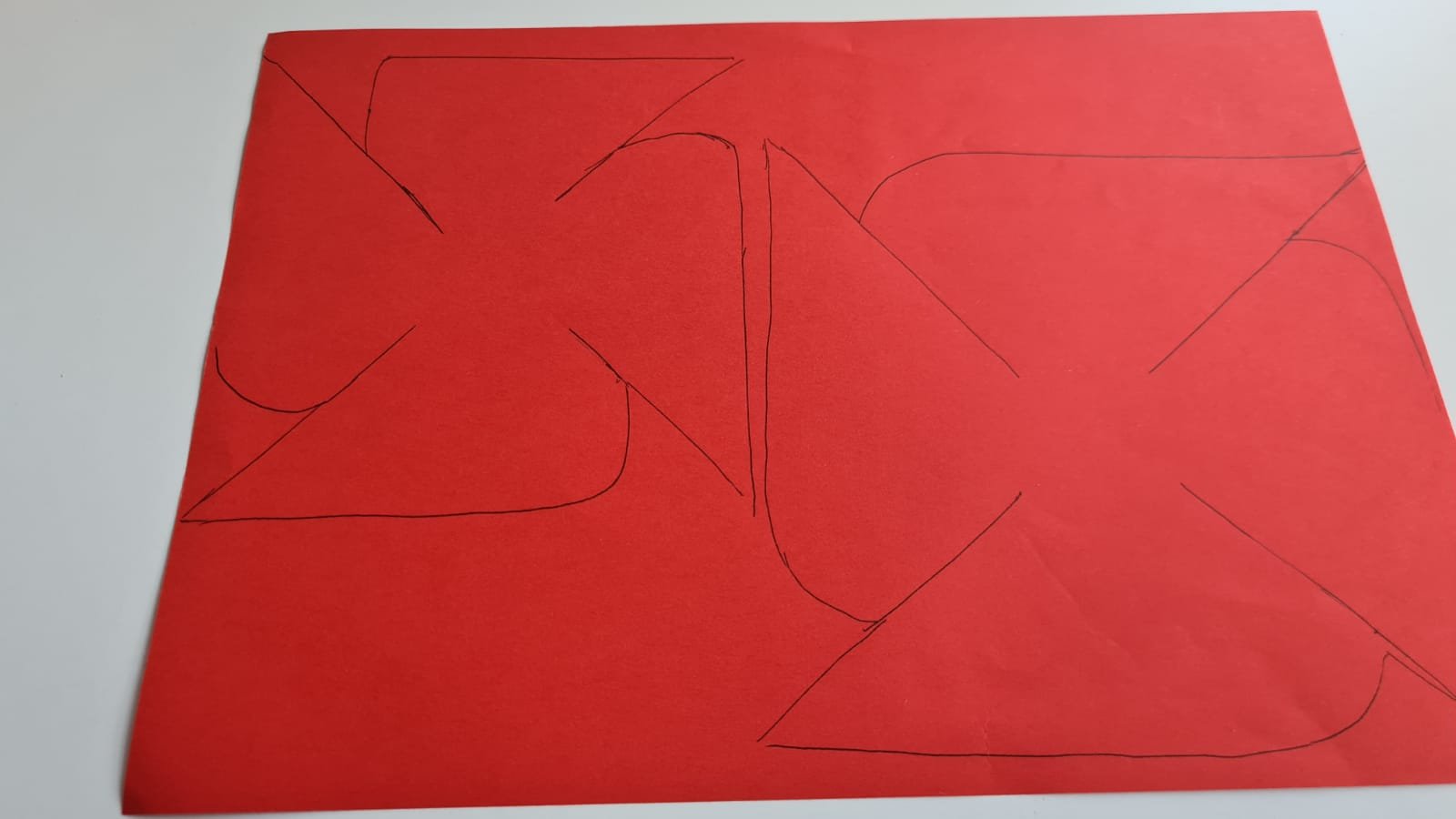 Red paper with geometric poppy design drawn on it