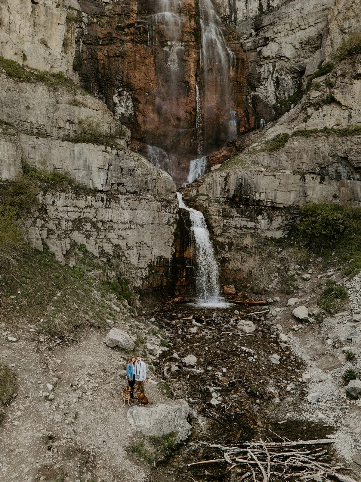 Couple standing beneath Stewart Falls waterfall in Provo Canyon near Sundance, Utah