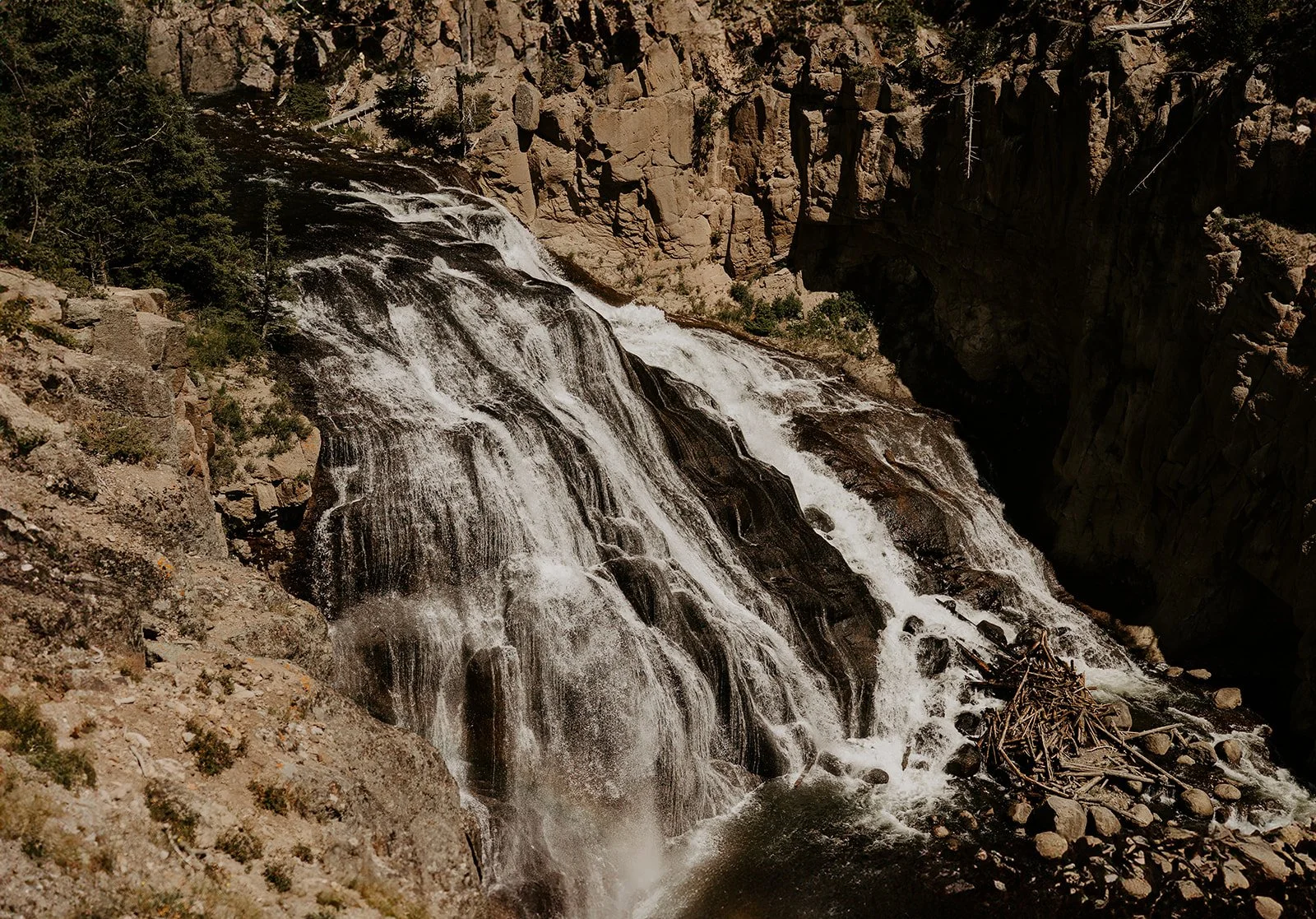 Gibbon Falls waterfall in Yellowstone National Park cascading through volcanic canyon landscape in Wyoming