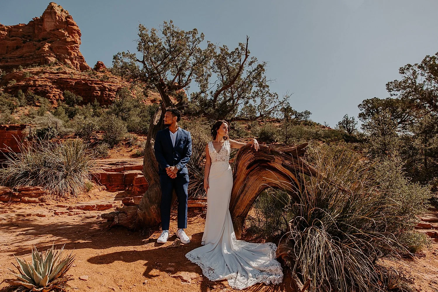 Colleen and Damon standing in front of a tree split by lightning at the Devil's Kitchen sink hole in Sedona.