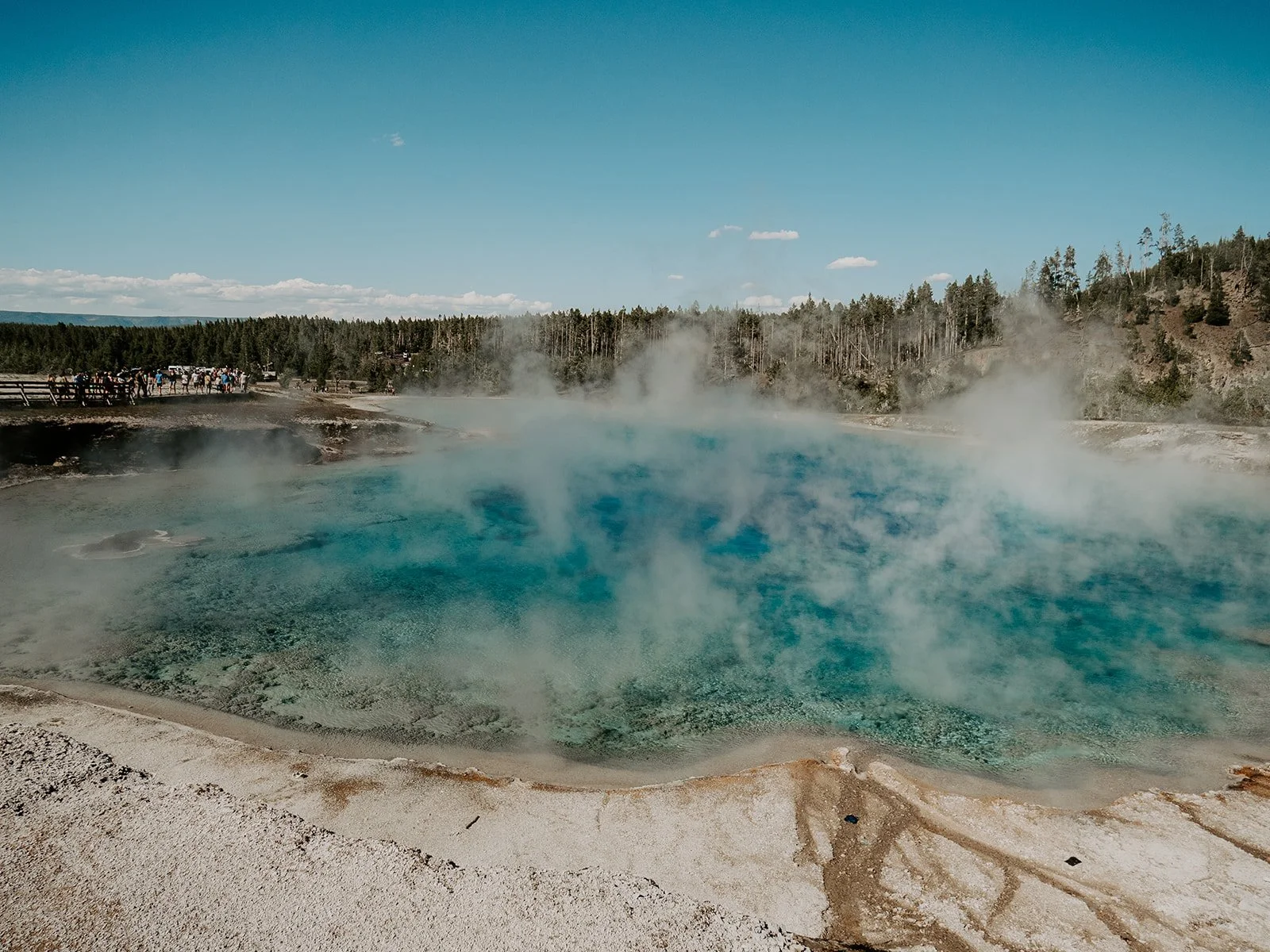 Steam rising from the vivid blue waters of Excelsior Geyser Crater in Yellowstone National Park.