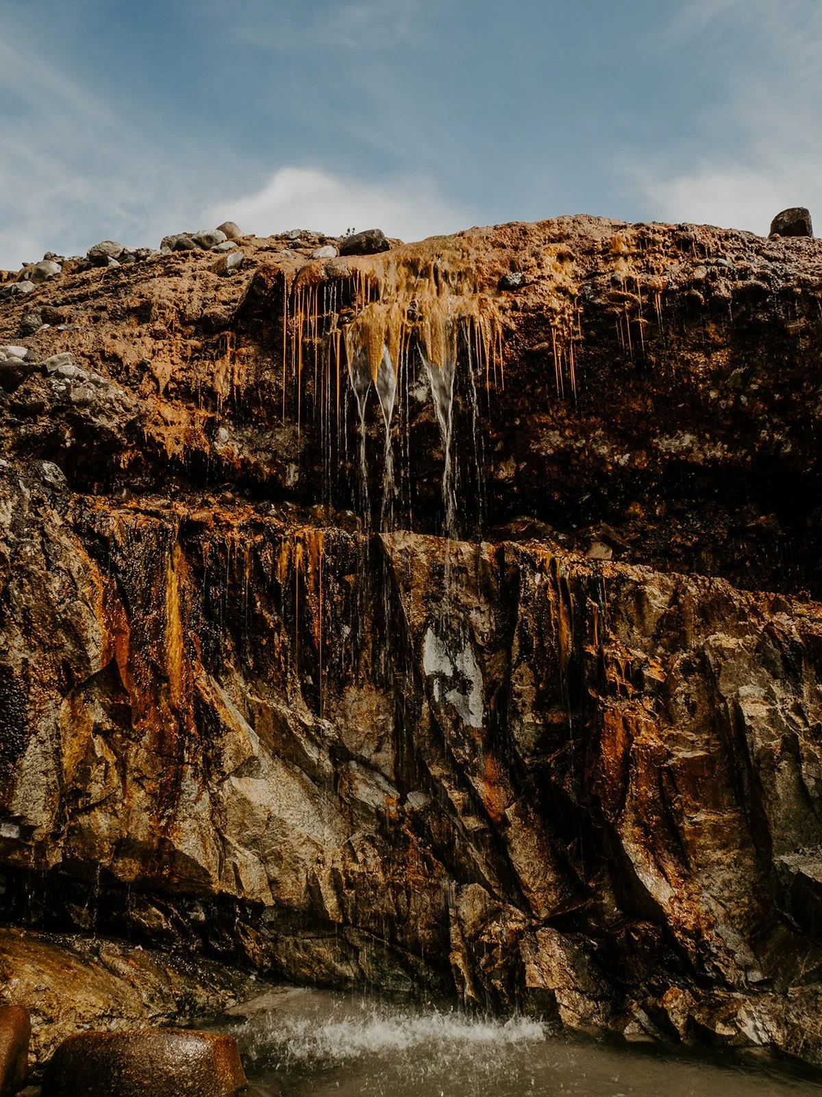 Hot spring waterfalls flowing over mineral cliffs at Kirkham Hot Springs in Boise National Forest, Idaho
