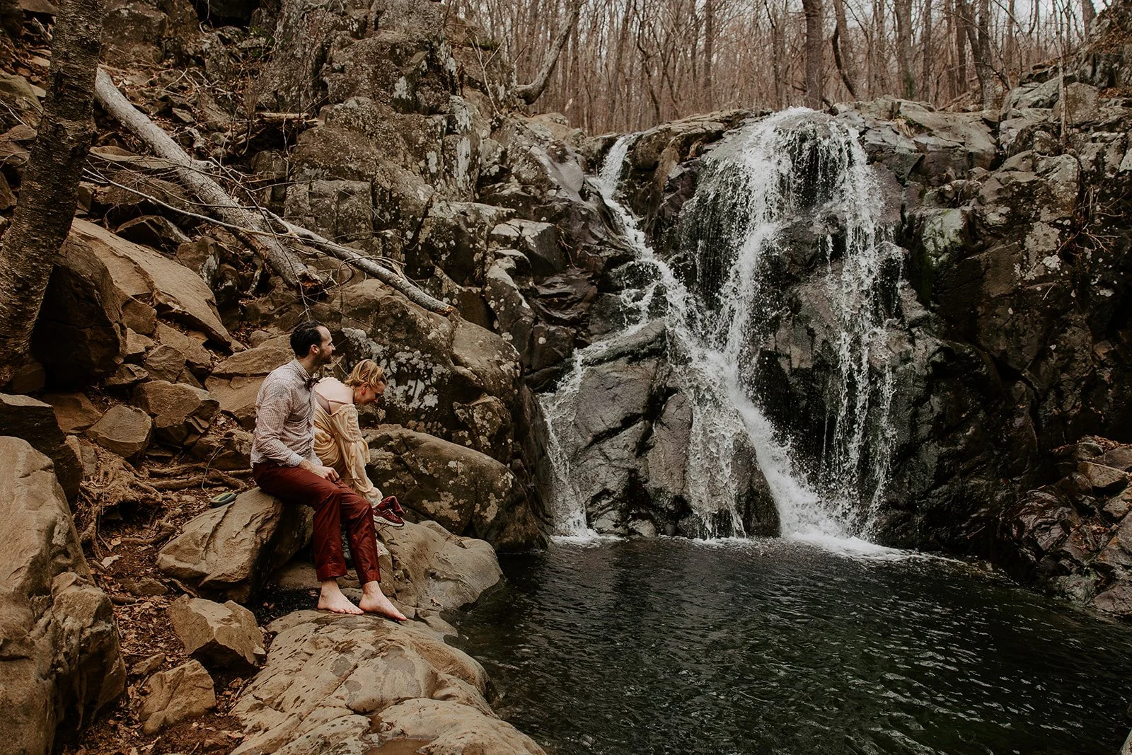 Couple resting beside Rose River Falls in Shenandoah National Park after jumping in the water
