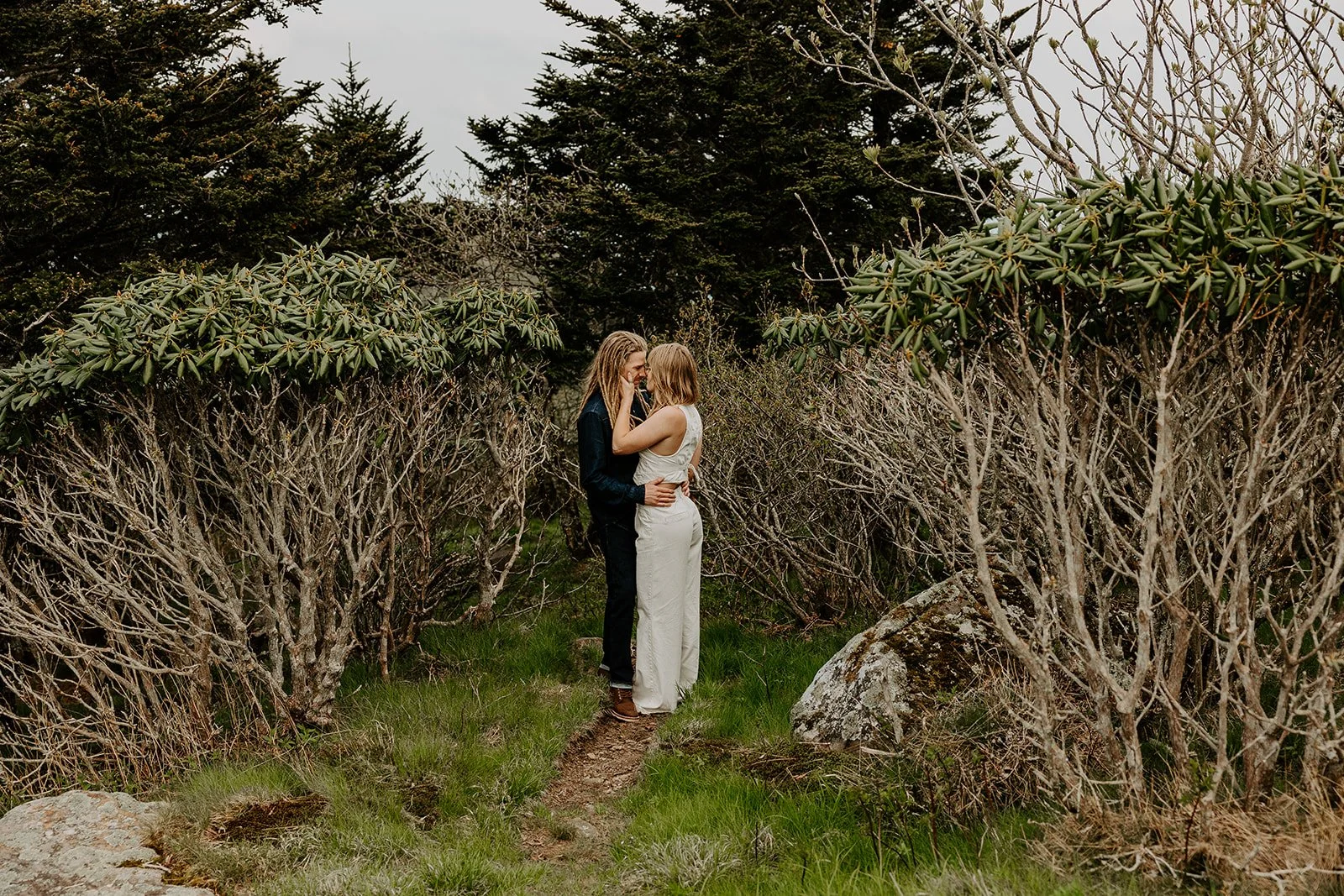 Couple standing together on a forest trail during a West Virginia elopement.