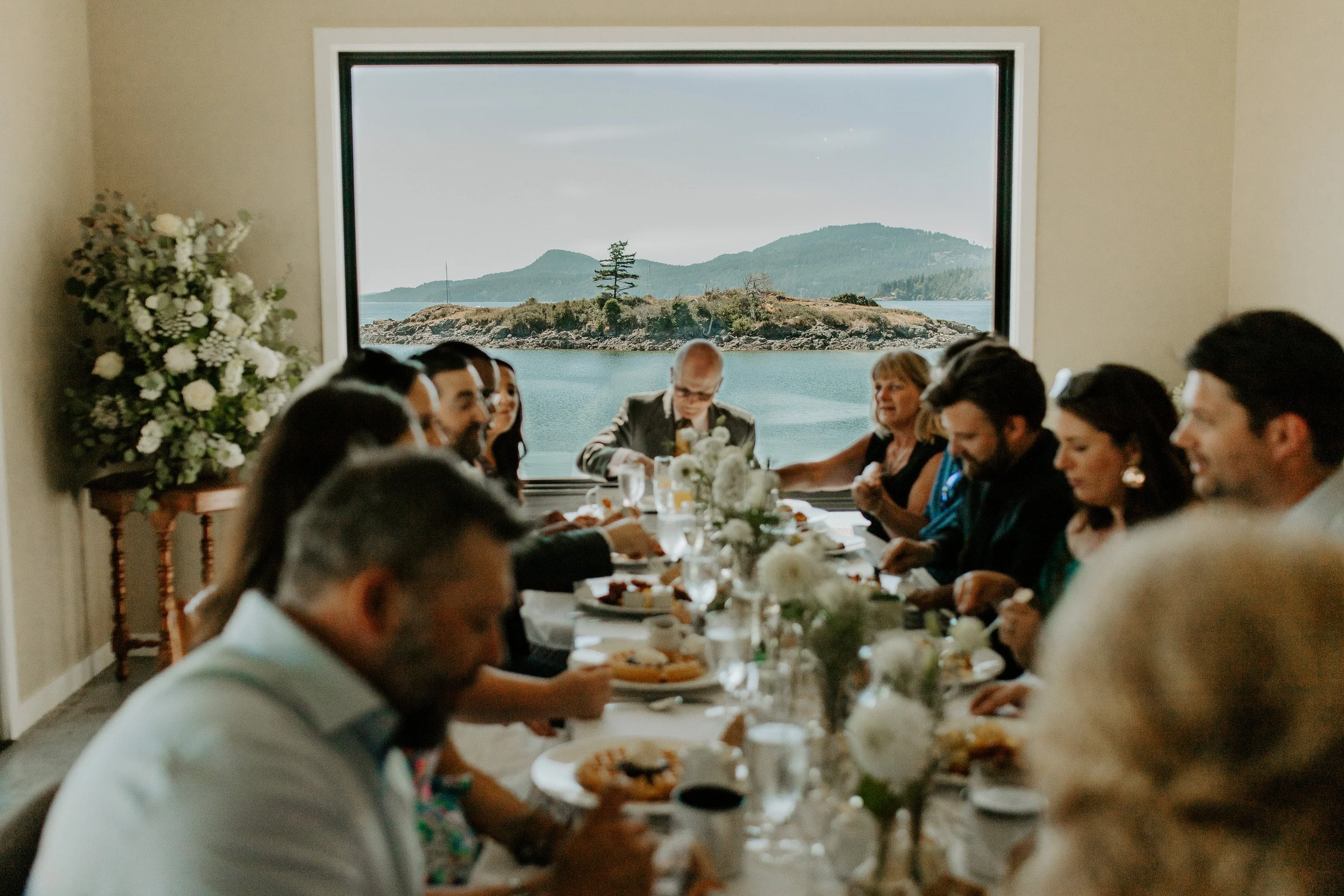 Wedding guests eating breakfast together inside Water’s Edge venue at The Outlook Inn on Orcas Island.