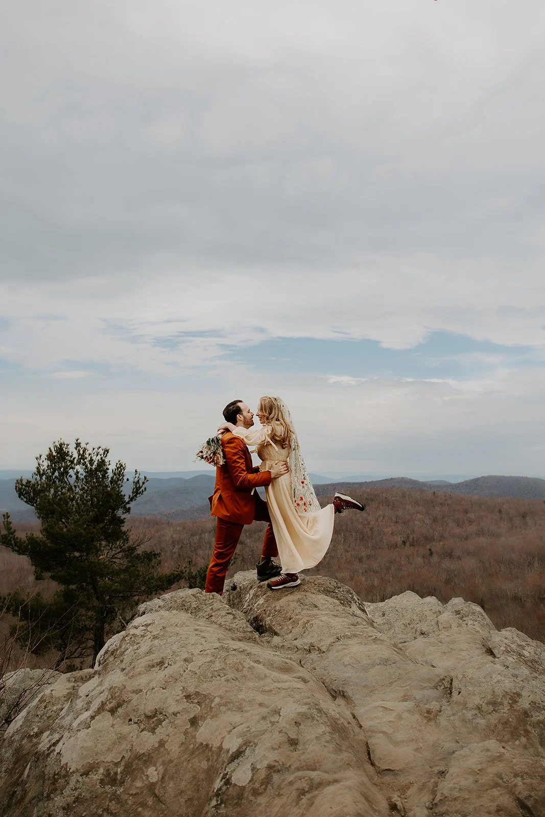 Couple embracing on a rocky mountain overlook during a quiet adventure elopement