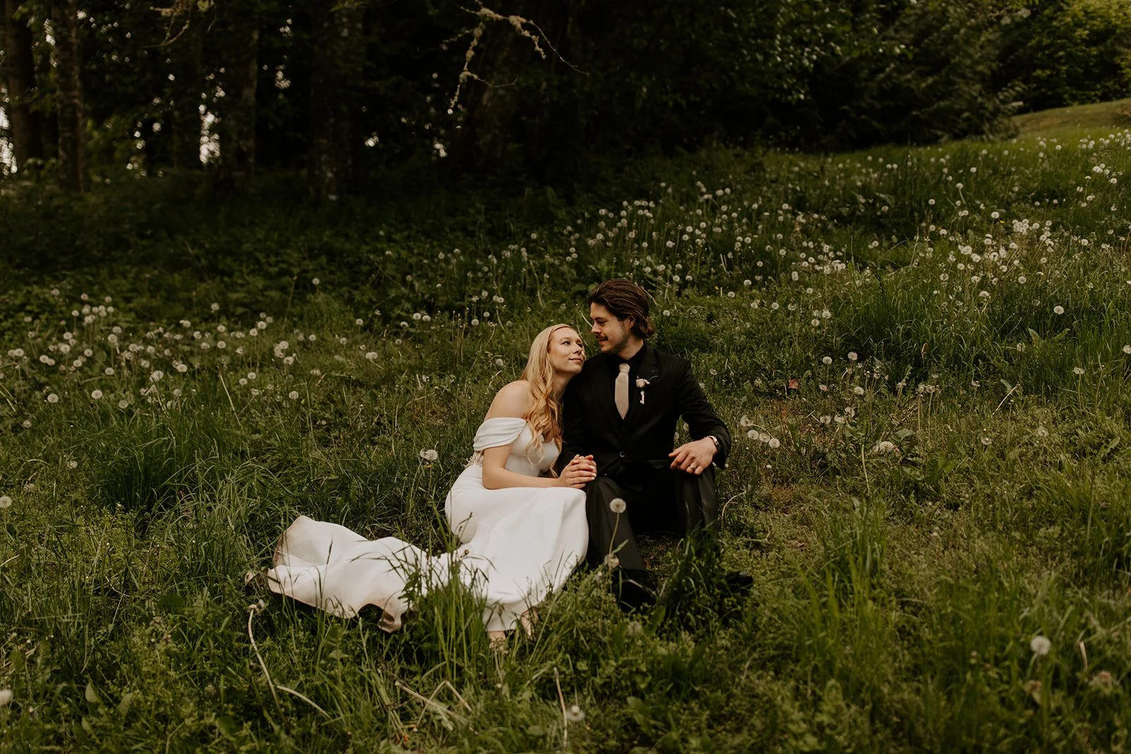 A bride looking up at her new husband in a field of wildflowers, giving new definition to what does elope mean