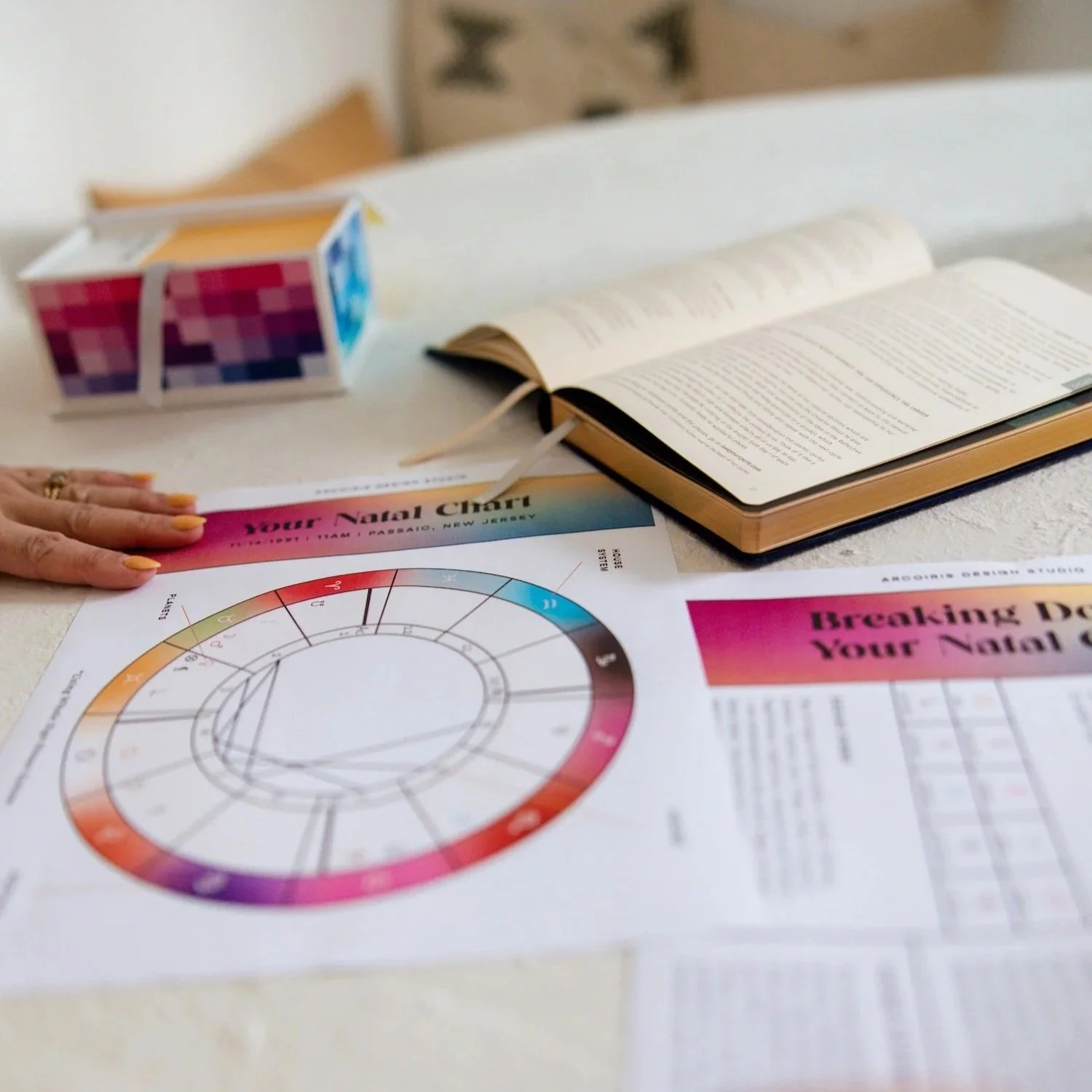 Natal chart from an astrobranding reading with a Pantone color book and an open astrology book