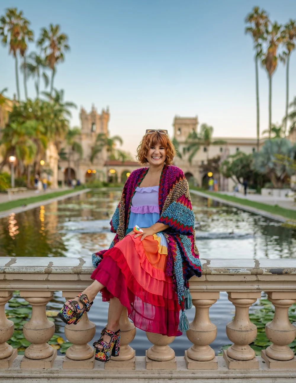 Alex McGinness, brand strategist and designer, smiling in a colorful knit wrap