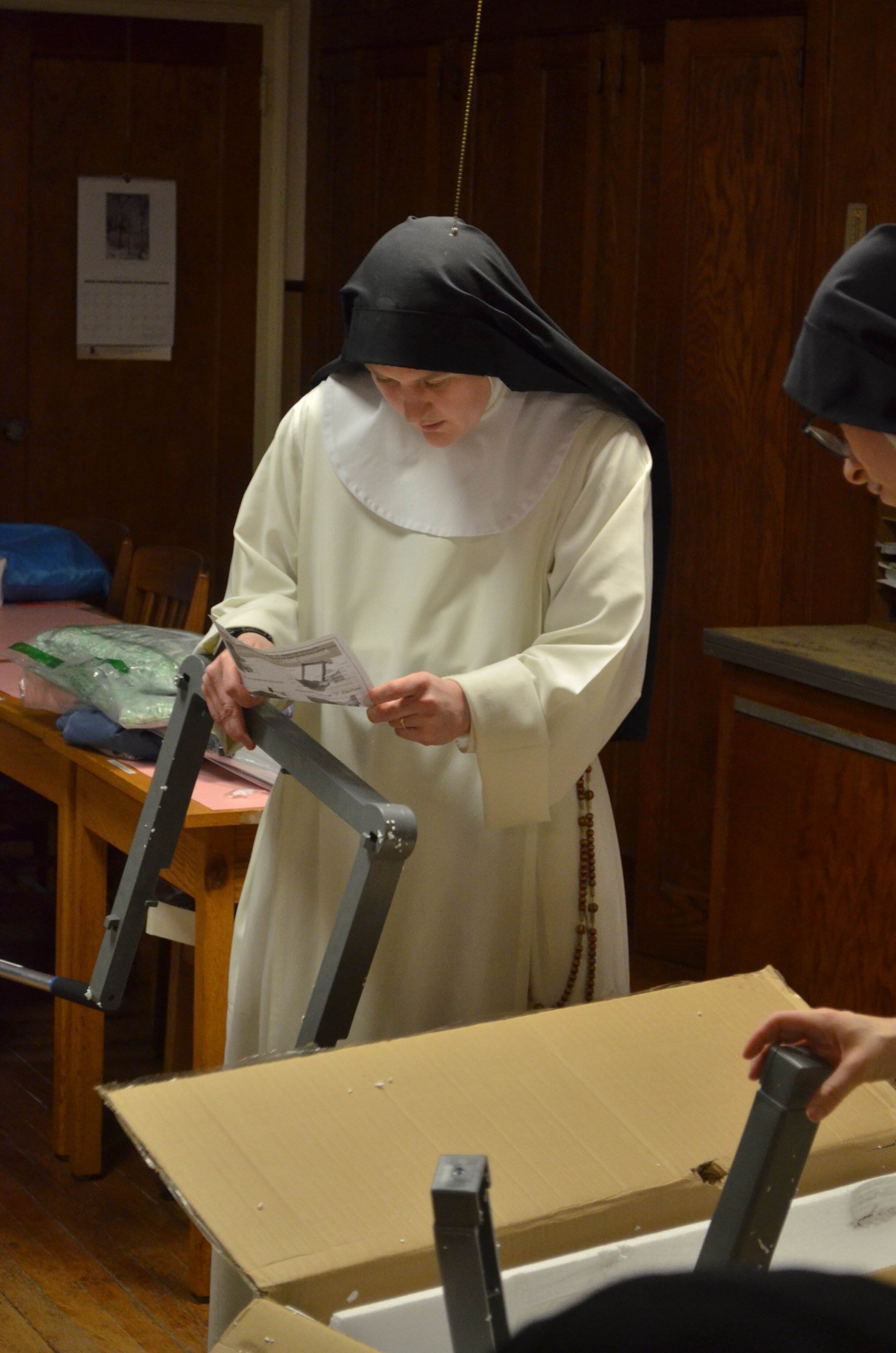 Sr. Mary Magdalene studies the instructions for the cleaning cart
