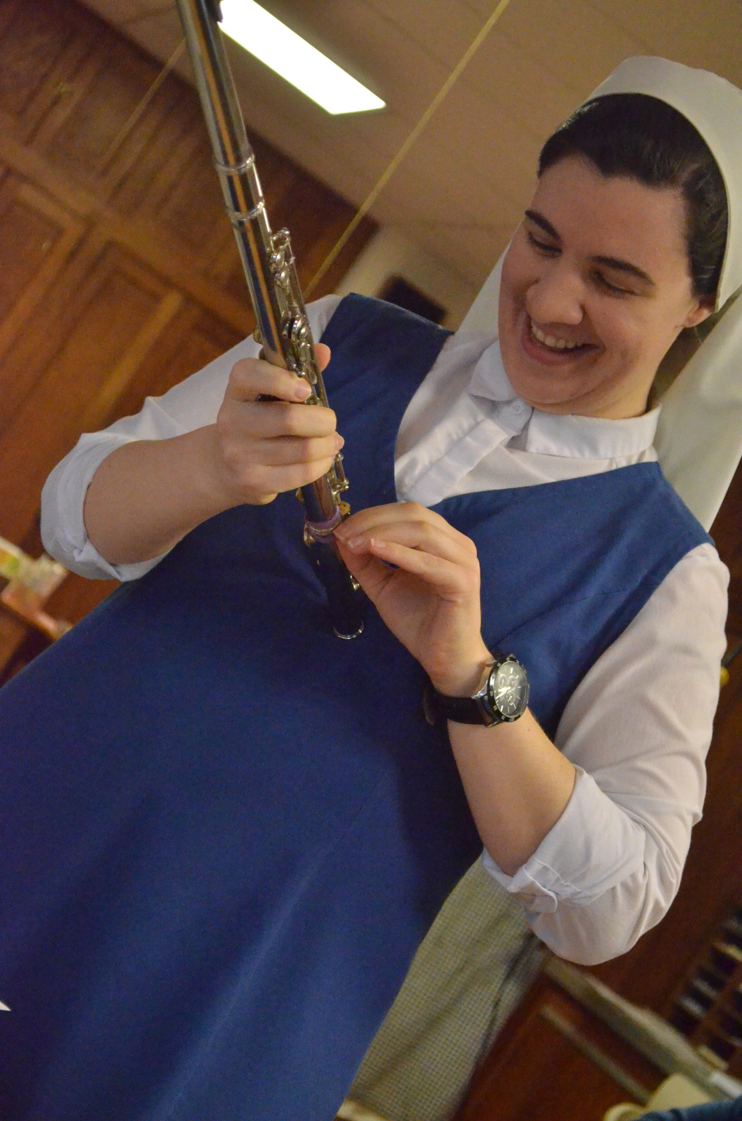 Sr. Lauren adjusts the purple rubberband she uses to hold the end of the flute on...