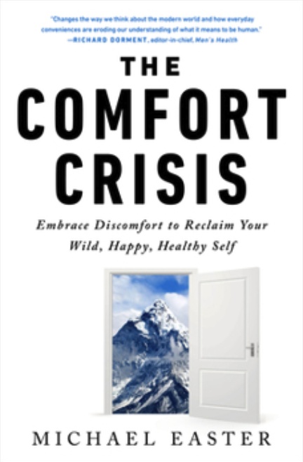 Book cover for 'The Comfort Crisis' by Michael Easter, featuring a white door open to reveal a mountain landscape.