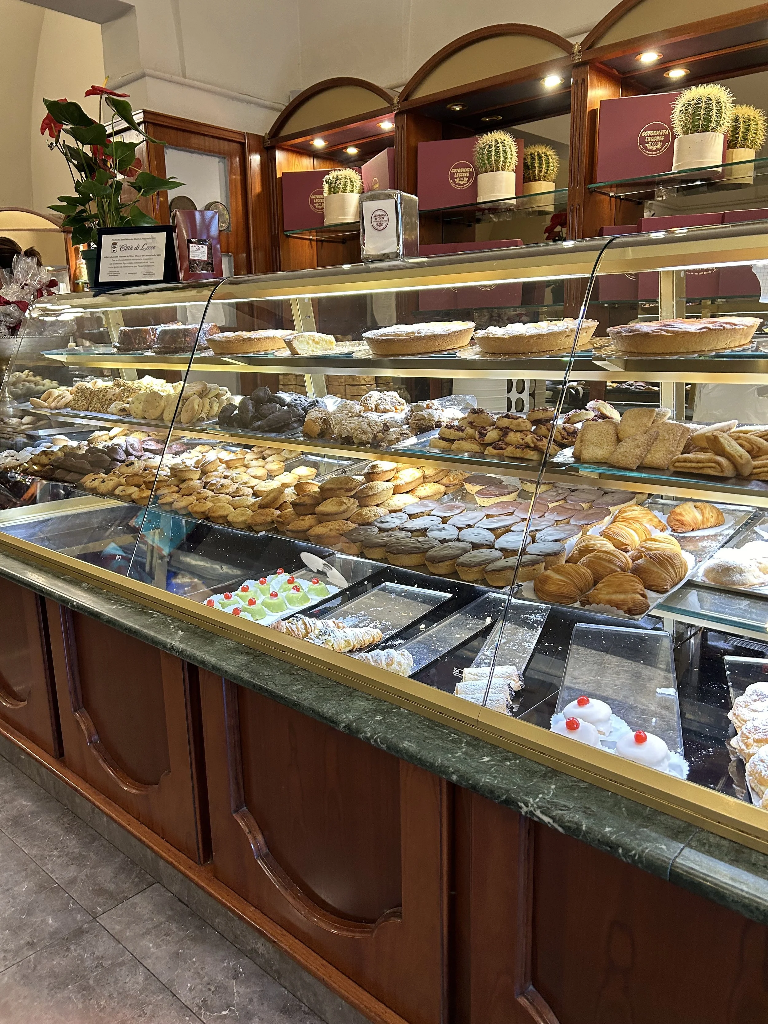 A display case filled with various pastries and desserts at a bakery.