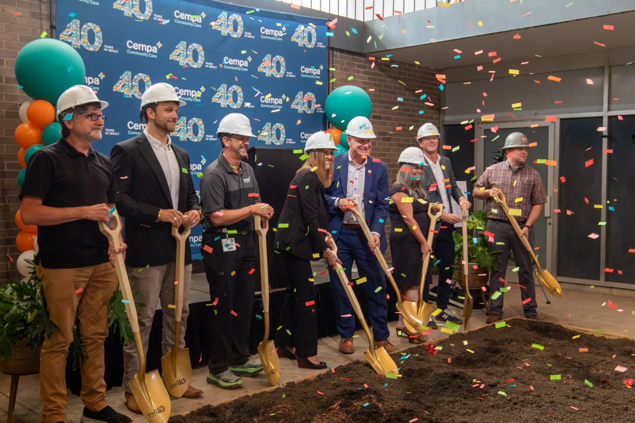 Photo of a line up at Cempa Groundbreaking in Chattanooga, TN featuring members of the Cempa team and P&C Construction with golden shovels and hard hats and confetti falling down in front of them.